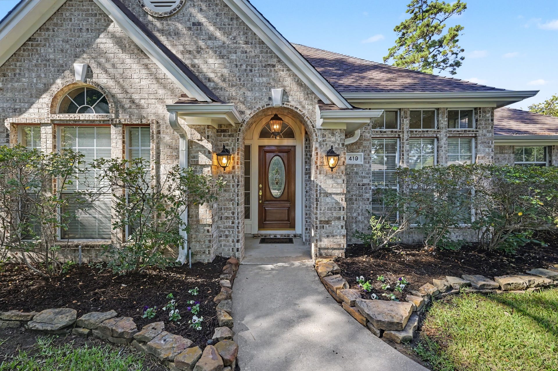 419 Dover Lane, Spring, TX 77373 Beautiful well maintained brick home surrounded by lush landscaping and stone-bordered flower beds.