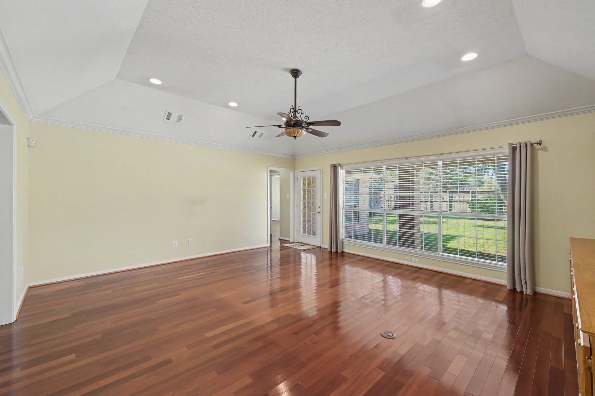 419 Dover Lane, Spring, TX 77373 Another view of the living area with rich hardwood floors, vaulted ceiling, and abundant natural light streaming through large windows overlooking the beautiful and oversized backyard.