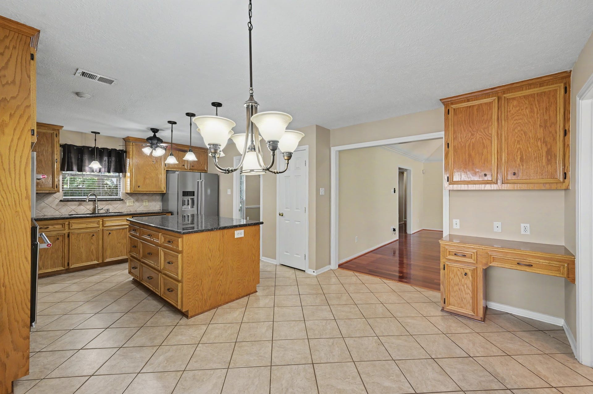 419 Dover Lane, Spring, TX 77373 Light & bright kitchen with warm wooden cabinetry, a large central island with granite countertops, and modern Kitchenaid stainless steel appliances.