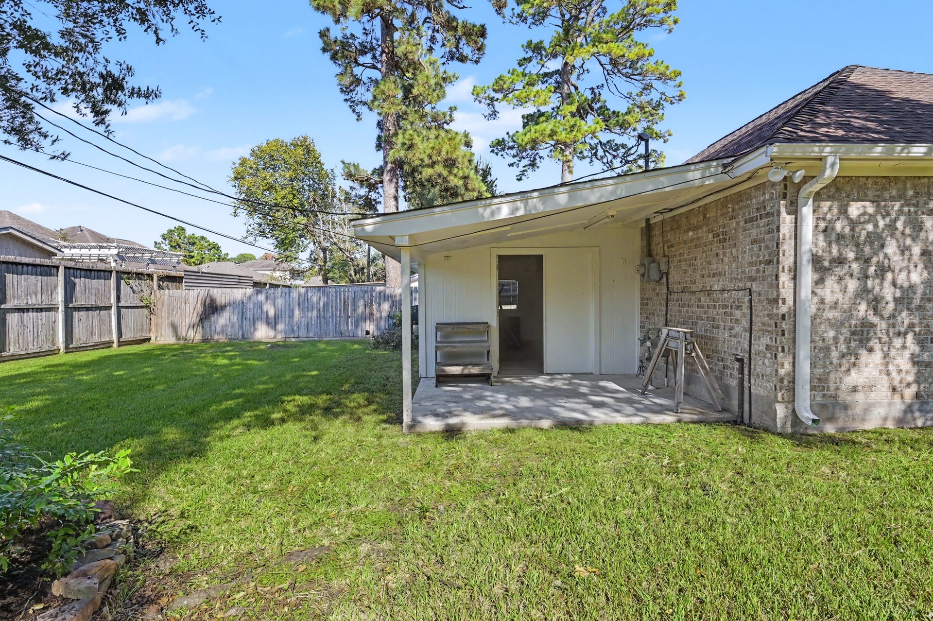 419 Dover Lane, Spring, TX 77373 View of the workshop off the back of the garage, surrounded by a privacy fence and mature trees.