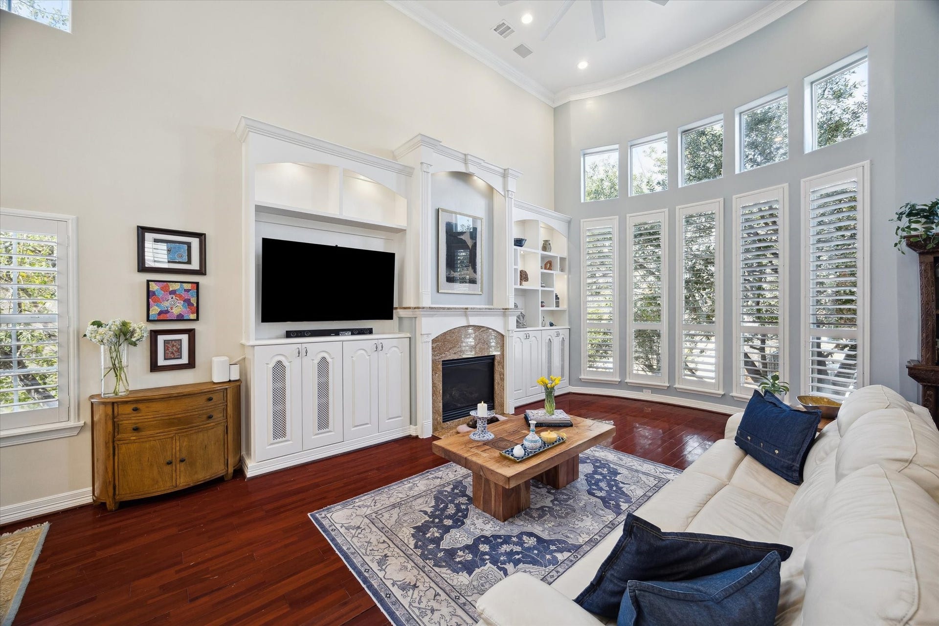 5717 Val Verde Street, #C, Houston, TX 77057 The inviting living room features high ceilings, large windows with plantation shutters, elegant built-in shelving, and wood floors. You will appreciate the privacy given by the mature tree outside and the warmth of this space.