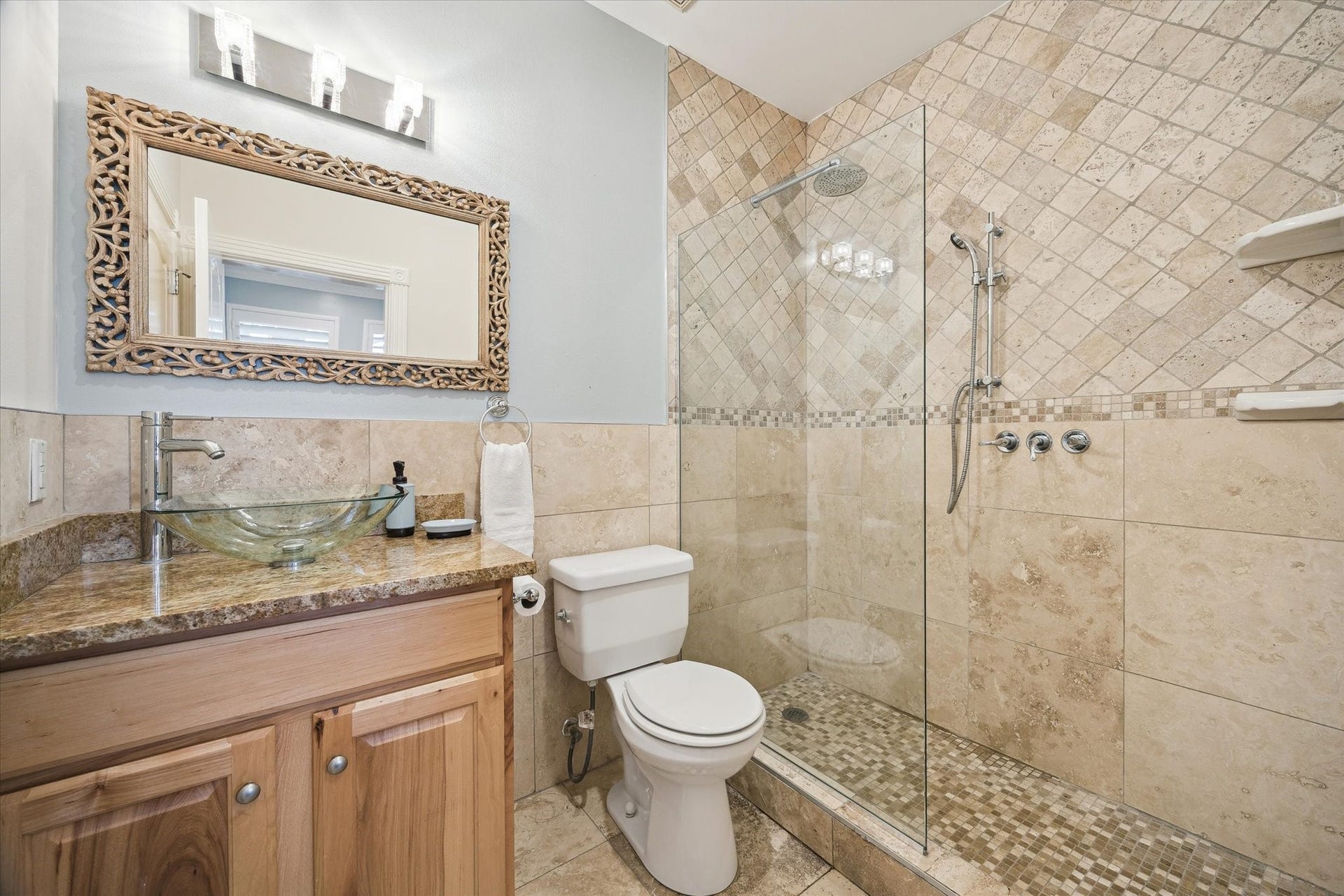 5717 Val Verde Street, #C, Houston, TX 77057 The bathroom is adjacent to the first floor bedroom, features a modern design with stone tile walls. The bathroom has access from the bedroom and the hallway.