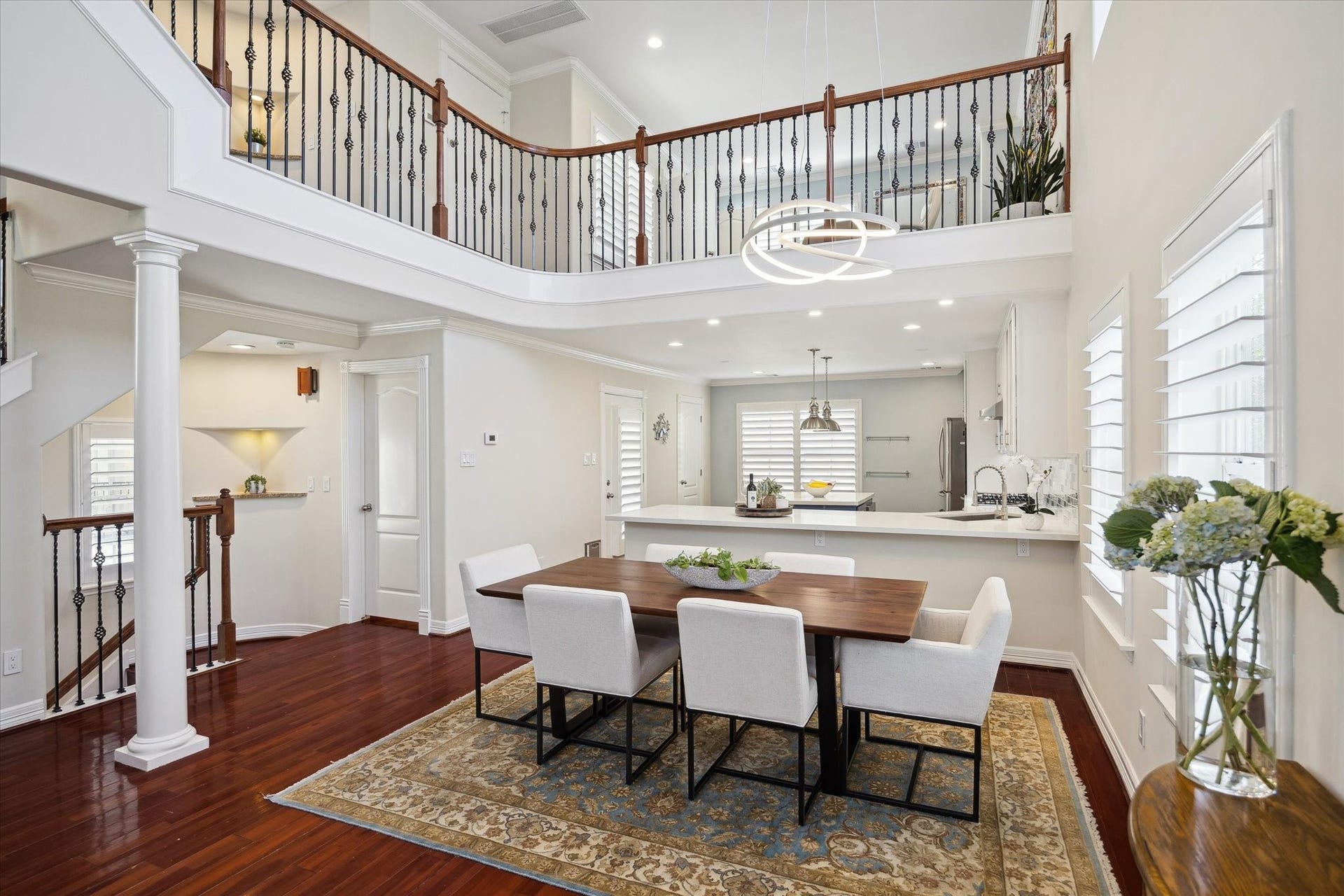 5717 Val Verde Street, #C, Houston, TX 77057 Dining and kitchen area with high ceilings and abundant natural light. The elegant wood flooring and modern fixtures create a warm, inviting atmosphere.