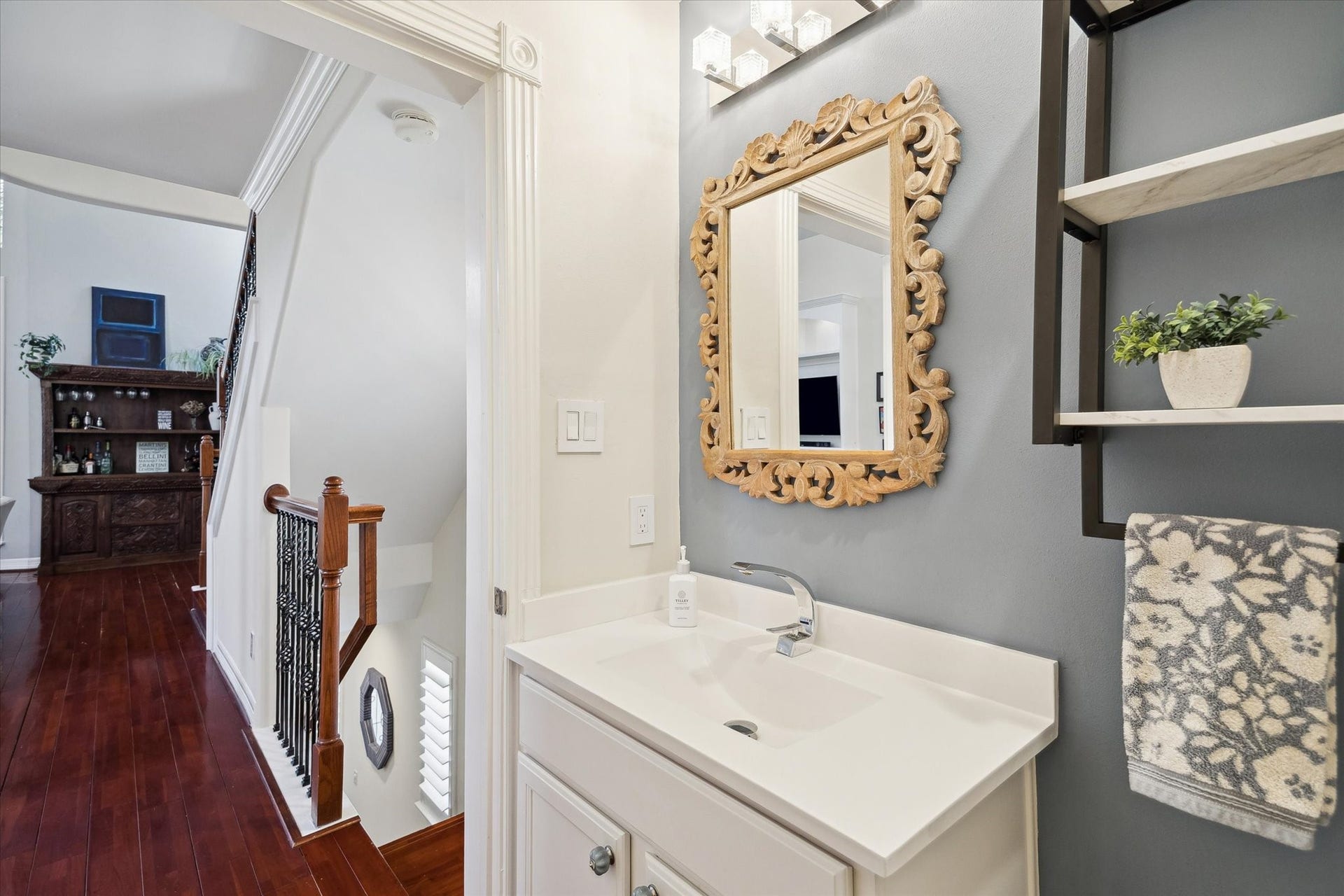 5717 Val Verde Street, #C, Houston, TX 77057 A half-bathroom tuck away for privacy, featuring a decorative mirror, modern lighting, and a sleek sink.