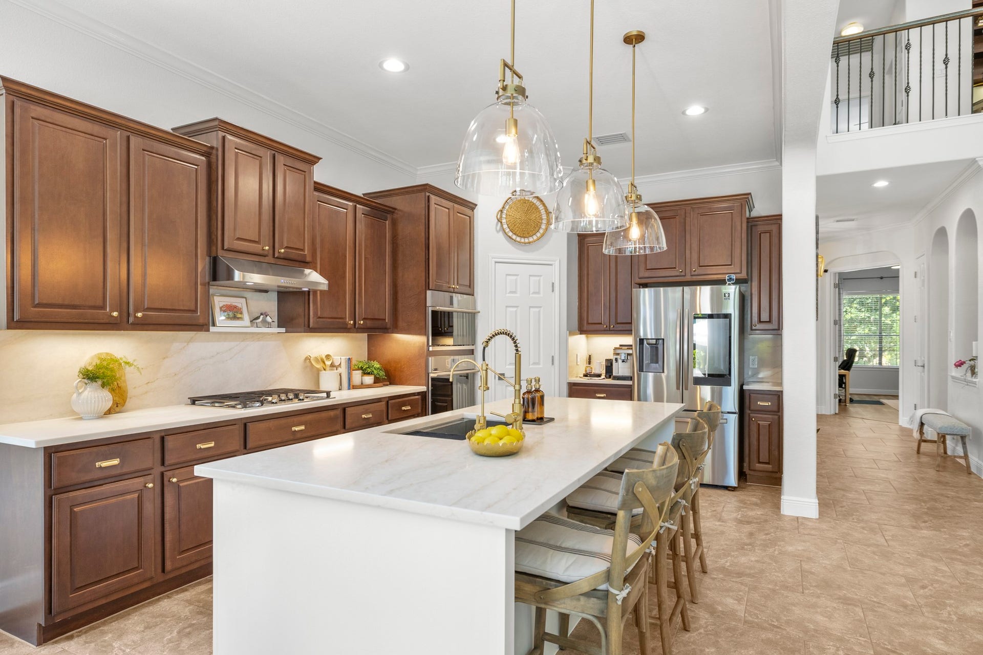 26 Winhall Place, The Woodlands, TX 77354 Quartz countertops and backsplash, designer glass pendants, and new stainless steel appliances make this space as beautiful as it is inviting.