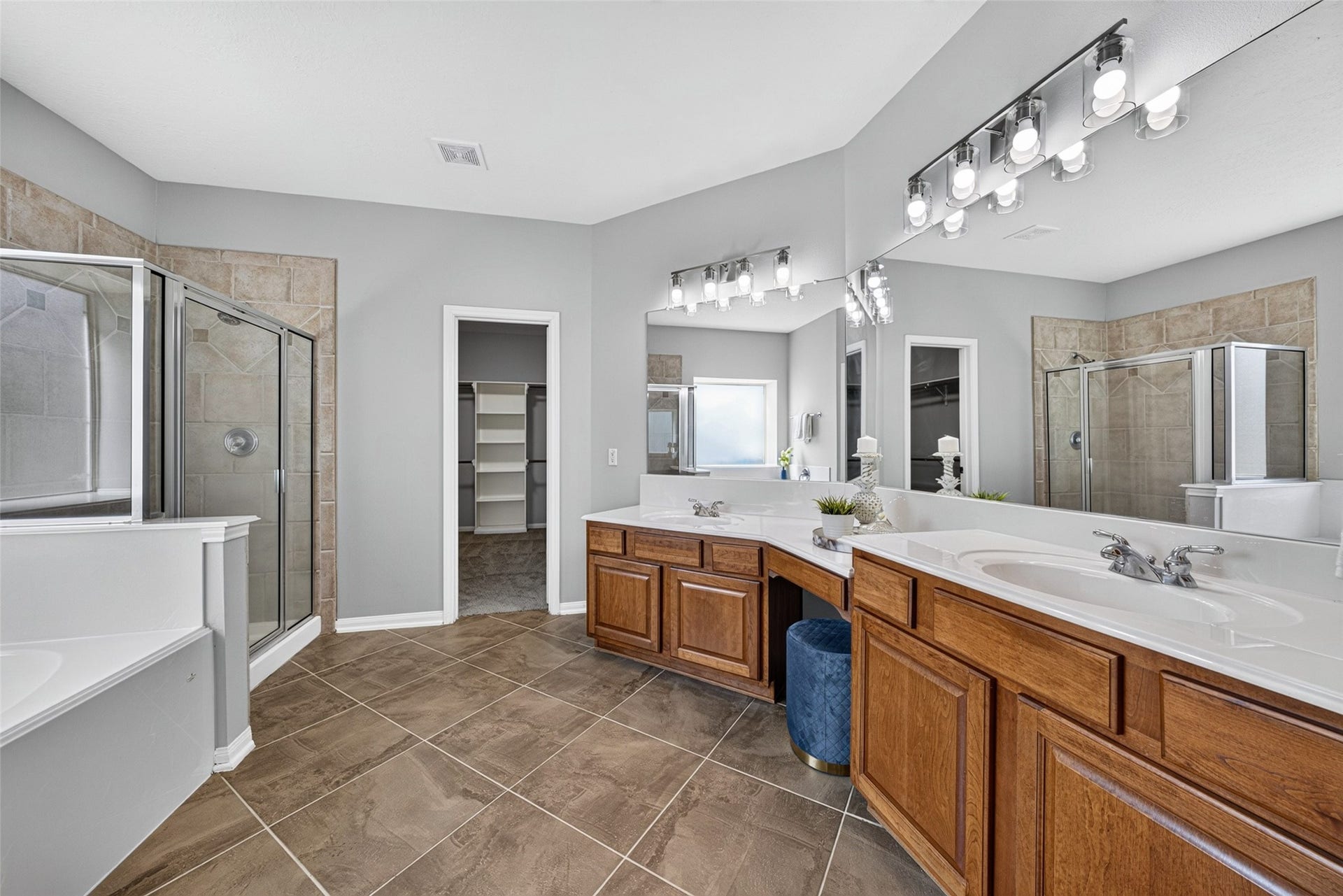 30 Palm Villas Drive, Manvel, TX 77578 Designed as a serene, spa-like retreat, this luxurious main-floor bathroom features an expansive double-sink vanity with warm wood cabinetry and generous counter space.