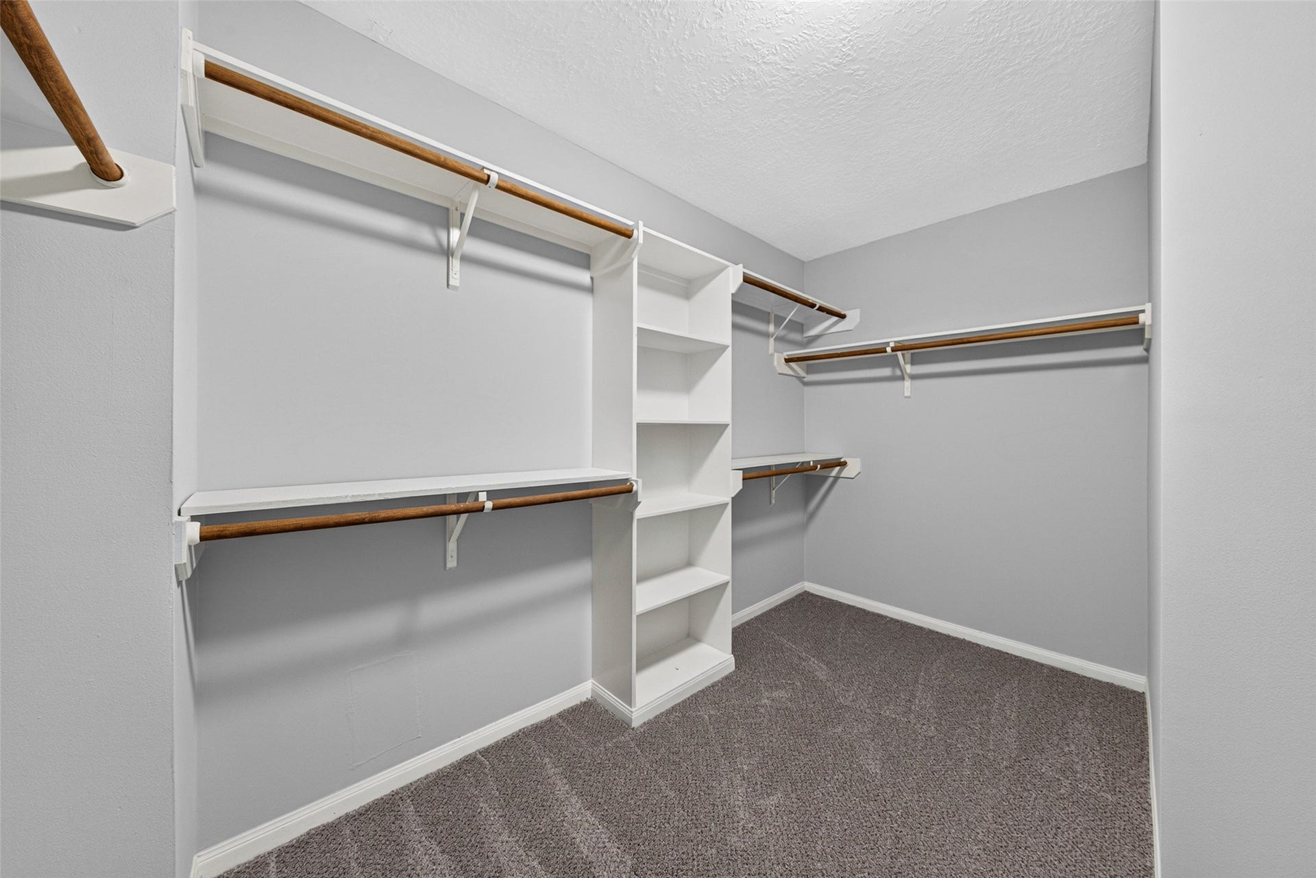 30 Palm Villas Drive, Manvel, TX 77578 Step inside this oversized walk-in closet featuring extensive custom built-in shelving, multi-level hanging racks, and dedicated shoe display cubbies designed to keep your wardrobe effortlessly organized.