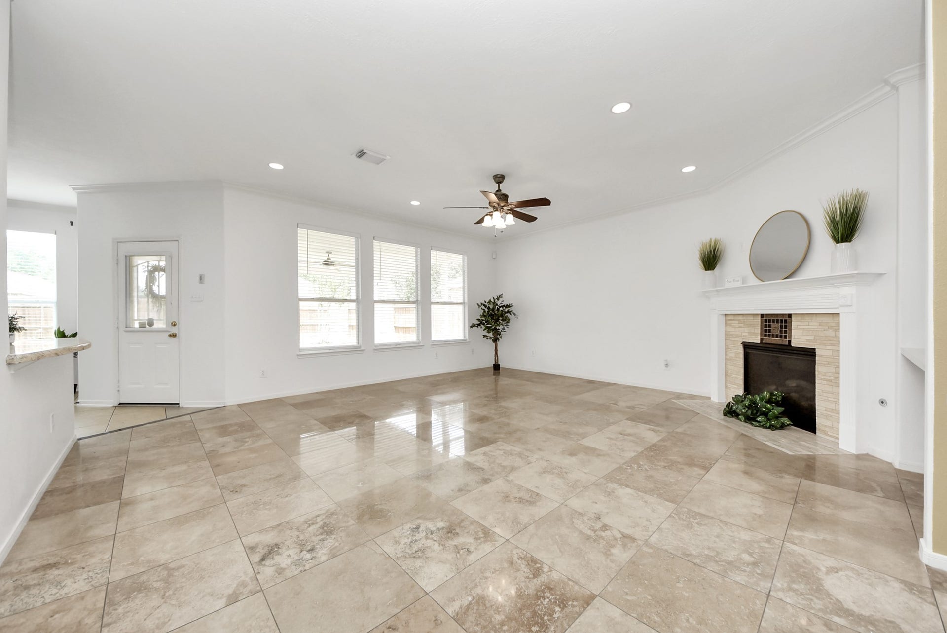 Beautiful travertine flooring extends throughout the main living area, creating warmth, durability, and a seamless foundation for both everyday life and entertaining.