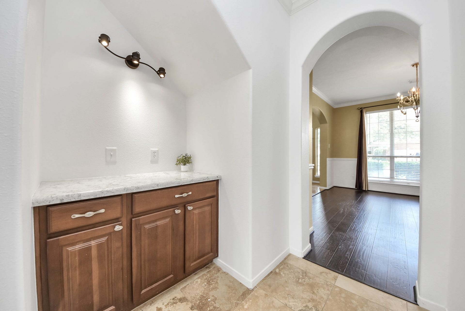 This bonus space between the kitchen and dining room adds both charm and function, featuring a stylish light fixture, additional countertop space, and even more cabinetry. Perfect for buffet-style serving during gatherings, a dedicated beverage station, or the deluxe coffee bar setup you've always wanted.