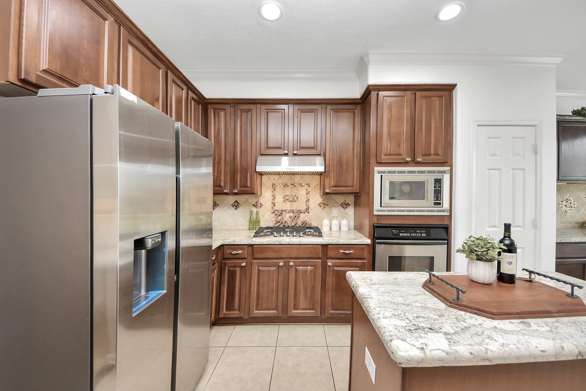 Warm maple cabinetry pairs beautifully with granite countertops, providing generous storage and timeless style for everyday cooking and organization.