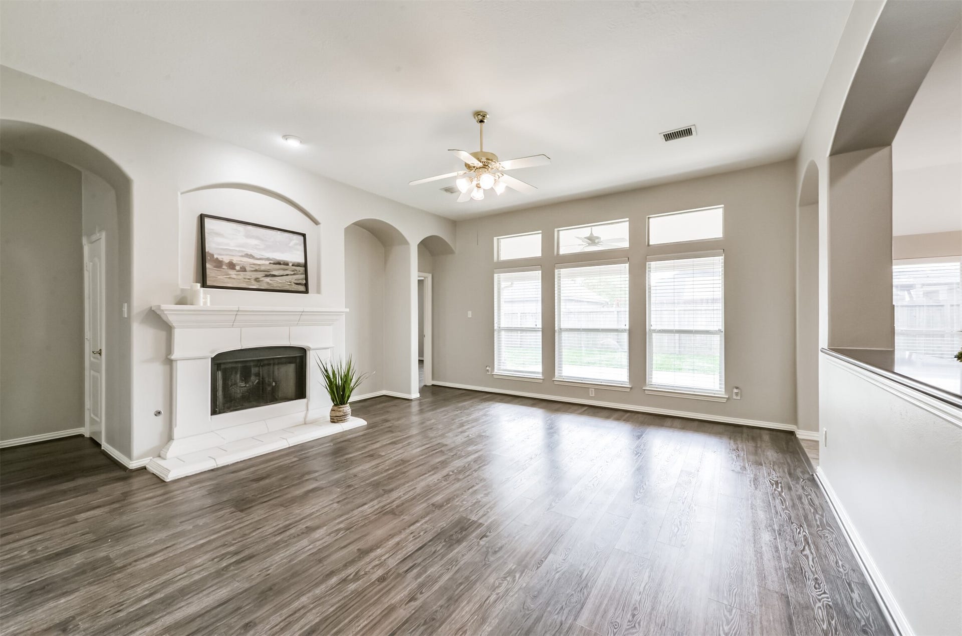 2606 Clay Creek Court, Pearland, TX 77581 Spacious den with wall of windows, cast stone gas log fireplace, beautiful vinyl plank floors. Den is open to kitchen.