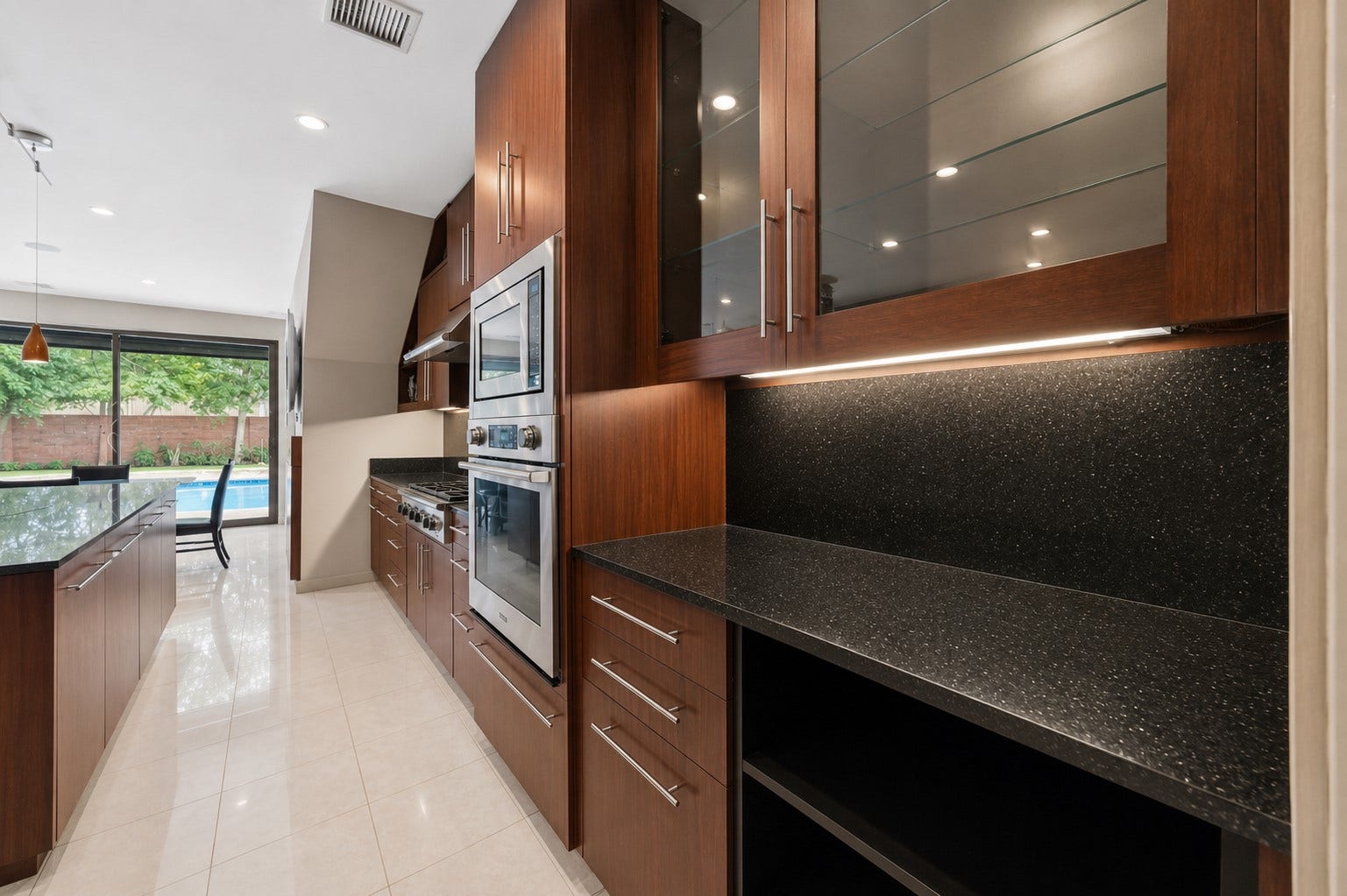 7610 Guinevere Drive, Sugar Land, TX 77479 A dedicated butler's pantry or prep station offers under-cabinet lighting, glass-front upper displays, and built-in double ovens.