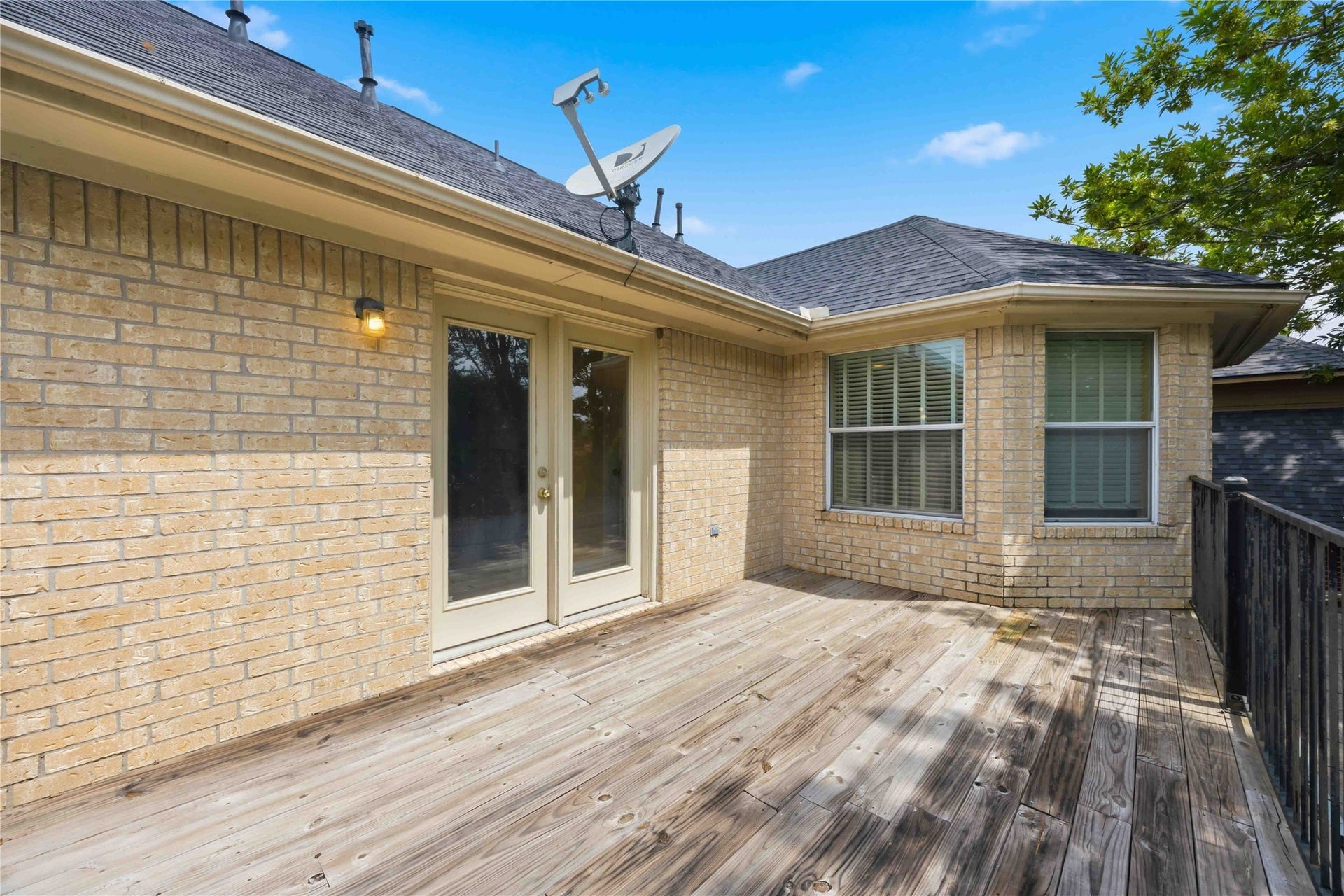 7610 Guinevere Drive, Sugar Land, TX 77479 The private balcony structure showcases a light brick exterior wall, a sliding double-door entry, and classic window trim.