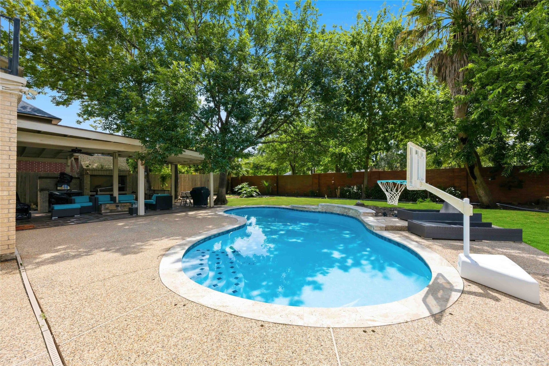7610 Guinevere Drive, Sugar Land, TX 77479 This outdoor oasis features a stone-lined pool deck that seamlessly transitions to a spacious covered entertainment pavilion.