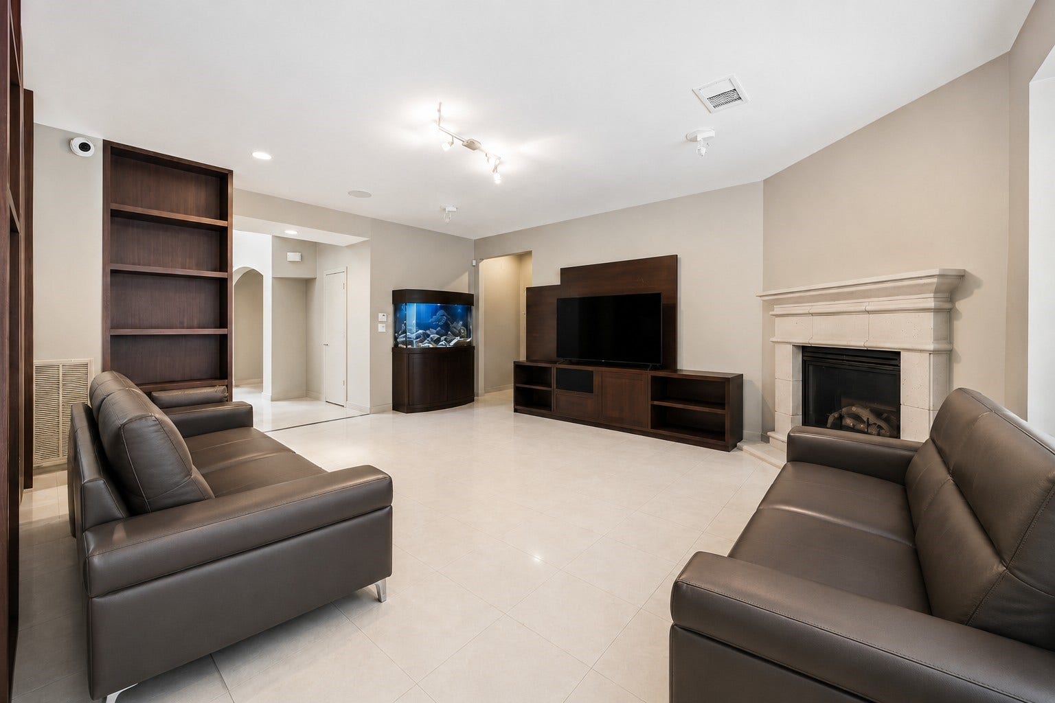 7610 Guinevere Drive, Sugar Land, TX 77479 An alternate angle of the family room highlights a sleek, custom-built entertainment unit matching the room's dark-stained wooden bookshelves.