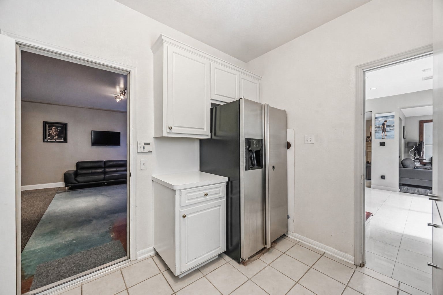 7610 Guinevere Drive, Sugar Land, TX 77479 A practical transition space offers white cabinetry with a light countertop alongside tile floors and an open doorway leading into the dedicated media room.