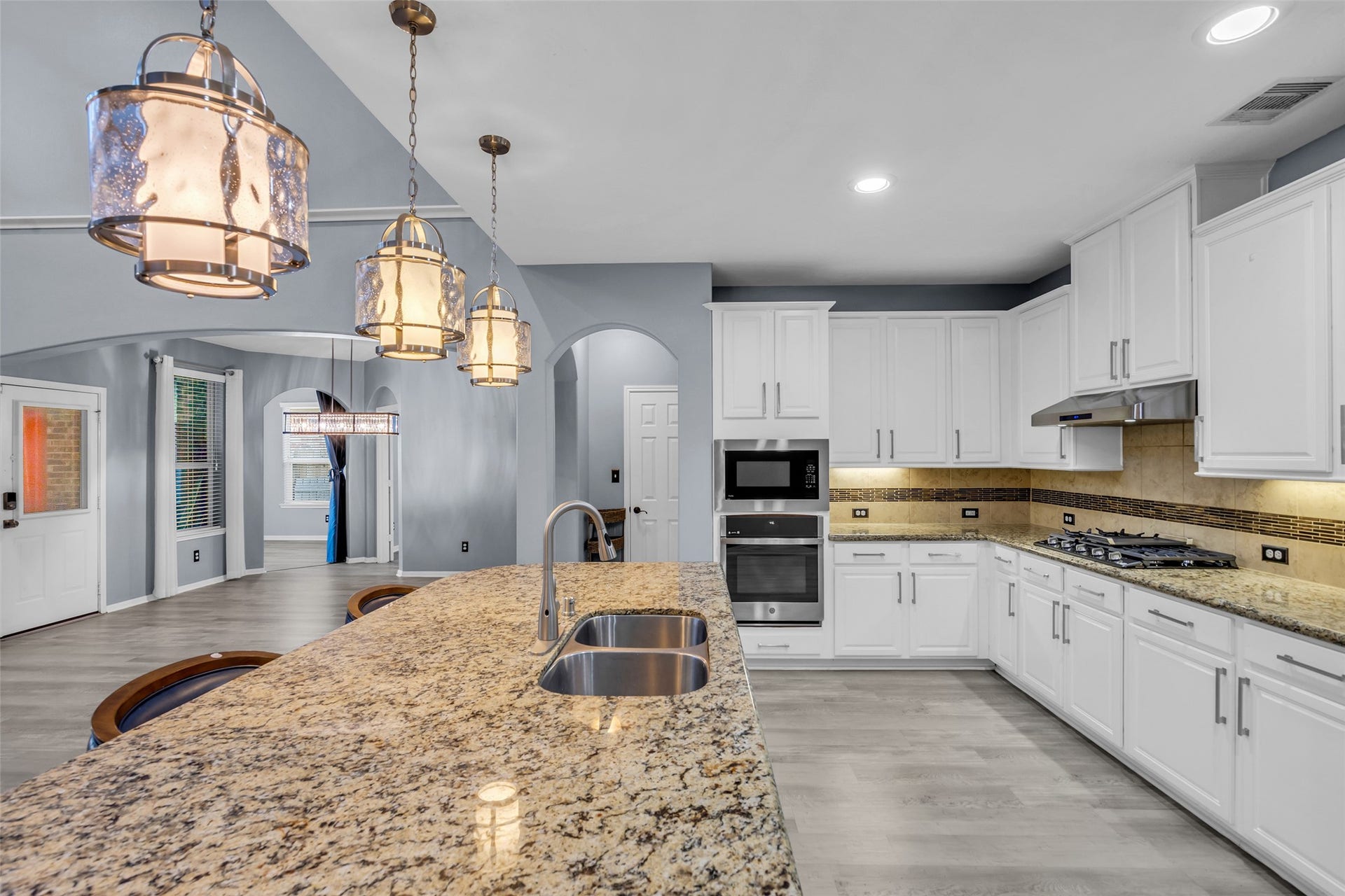 8121 Tranquil Lake Way, Conroe, TX 77385 Spacious kitchen with elegant granite countertops, stainless steel appliances, and stylish pendant lighting, offering a perfect blend of functionality and modern design.
