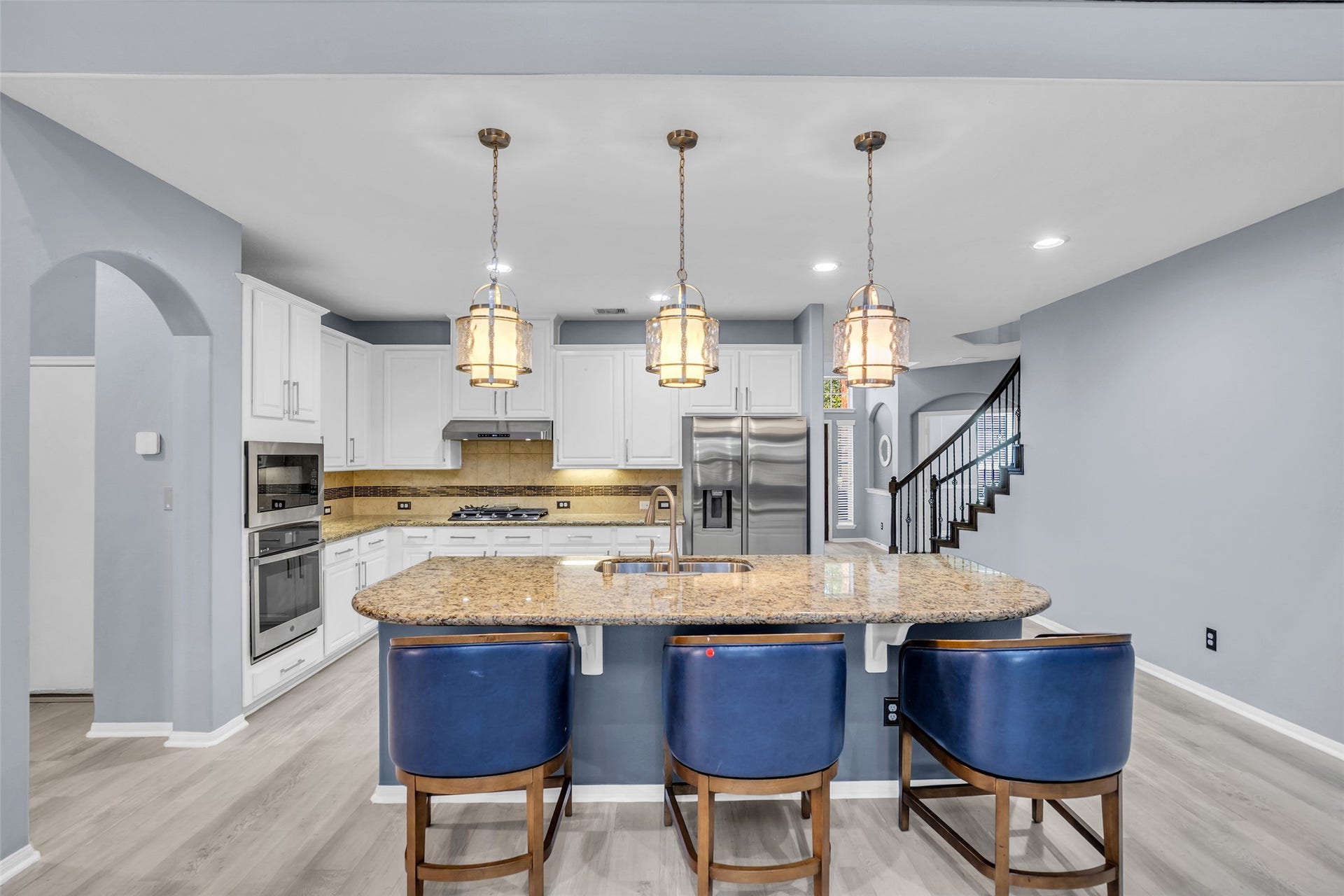 8121 Tranquil Lake Way, Conroe, TX 77385 Elegant kitchen with modern stainless steel appliances, granite countertops, and a spacious island with seating.