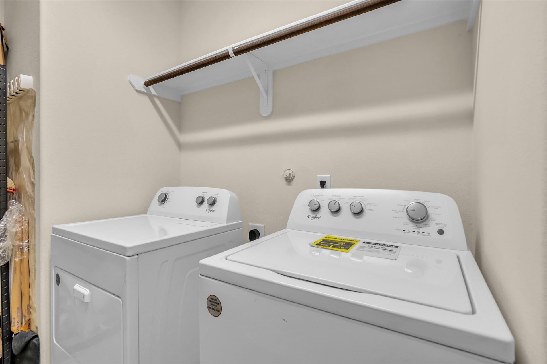 8121 Tranquil Lake Way, Conroe, TX 77385 Convenient laundry area with modern washer and dryer, featuring overhead shelving for additional storage.