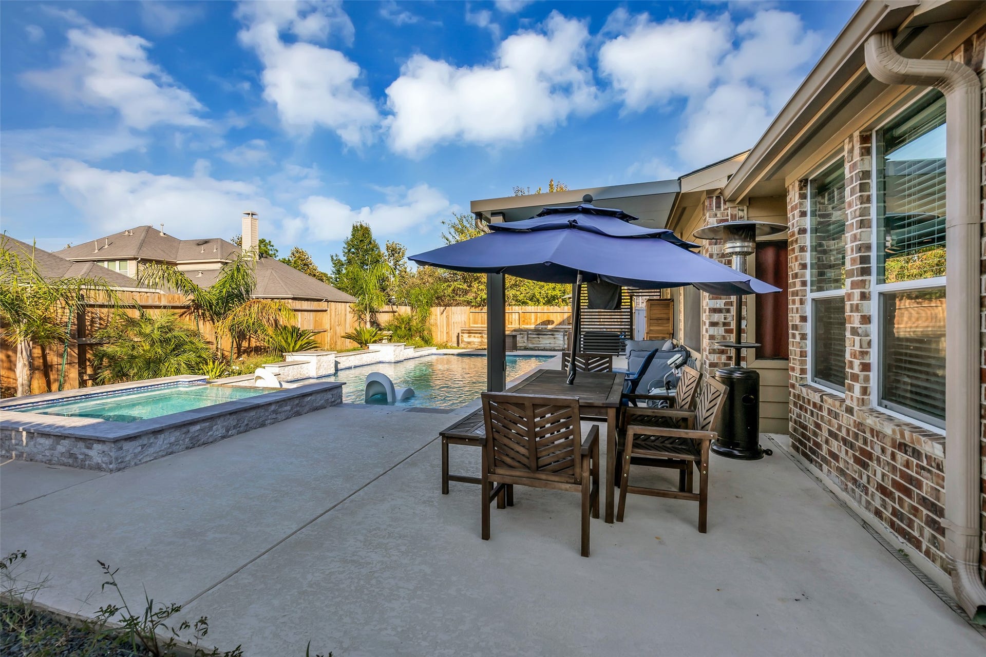 8121 Tranquil Lake Way, Conroe, TX 77385 Relax in a stunning backyard oasis featuring a sparkling pool, spacious patio, and stylish outdoor dining area, perfect for entertaining or unwinding.