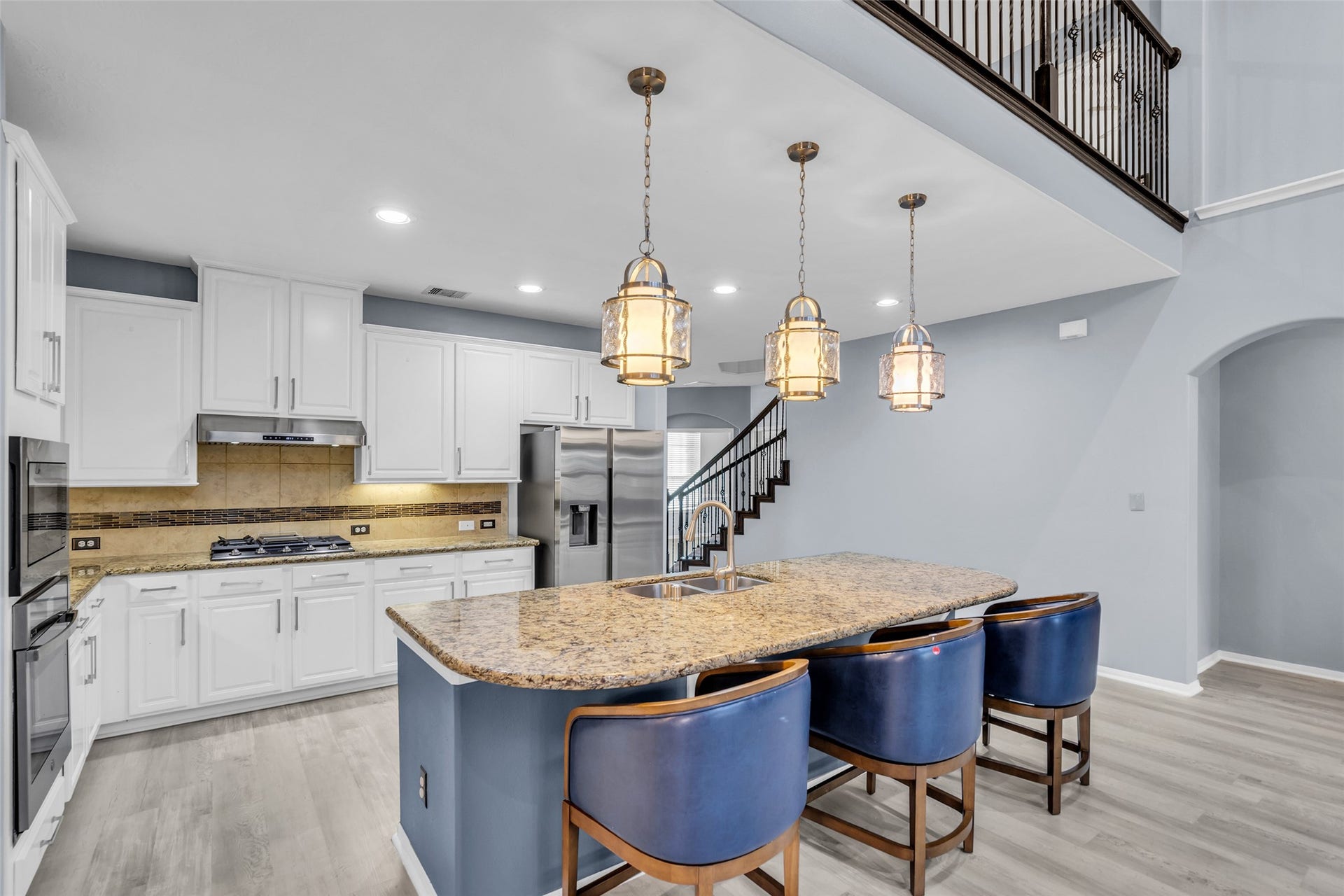 8121 Tranquil Lake Way, Conroe, TX 77385 Modern kitchen with a spacious island, elegant granite countertops, and stylish pendant lighting, complemented by sleek stainless steel appliances and crisp white cabinetry.