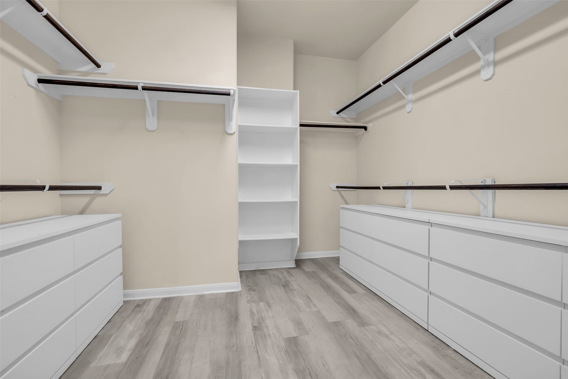8121 Tranquil Lake Way, Conroe, TX 77385 Spacious walk-in closet featuring ample shelving, multiple hanging rods, and sleek white cabinetry for organized storage.