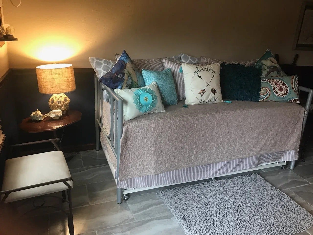 3709 Bayshore Drive, #1-12, Bacliff, TX 77518 Welcome to the Captain's Quartersa cozy retreat featuring a stylish daybed adorned with plush, nautical-themed pillows. Soft lighting and charming seaside decor create a warm, inviting atmosphere perfect for relaxation.