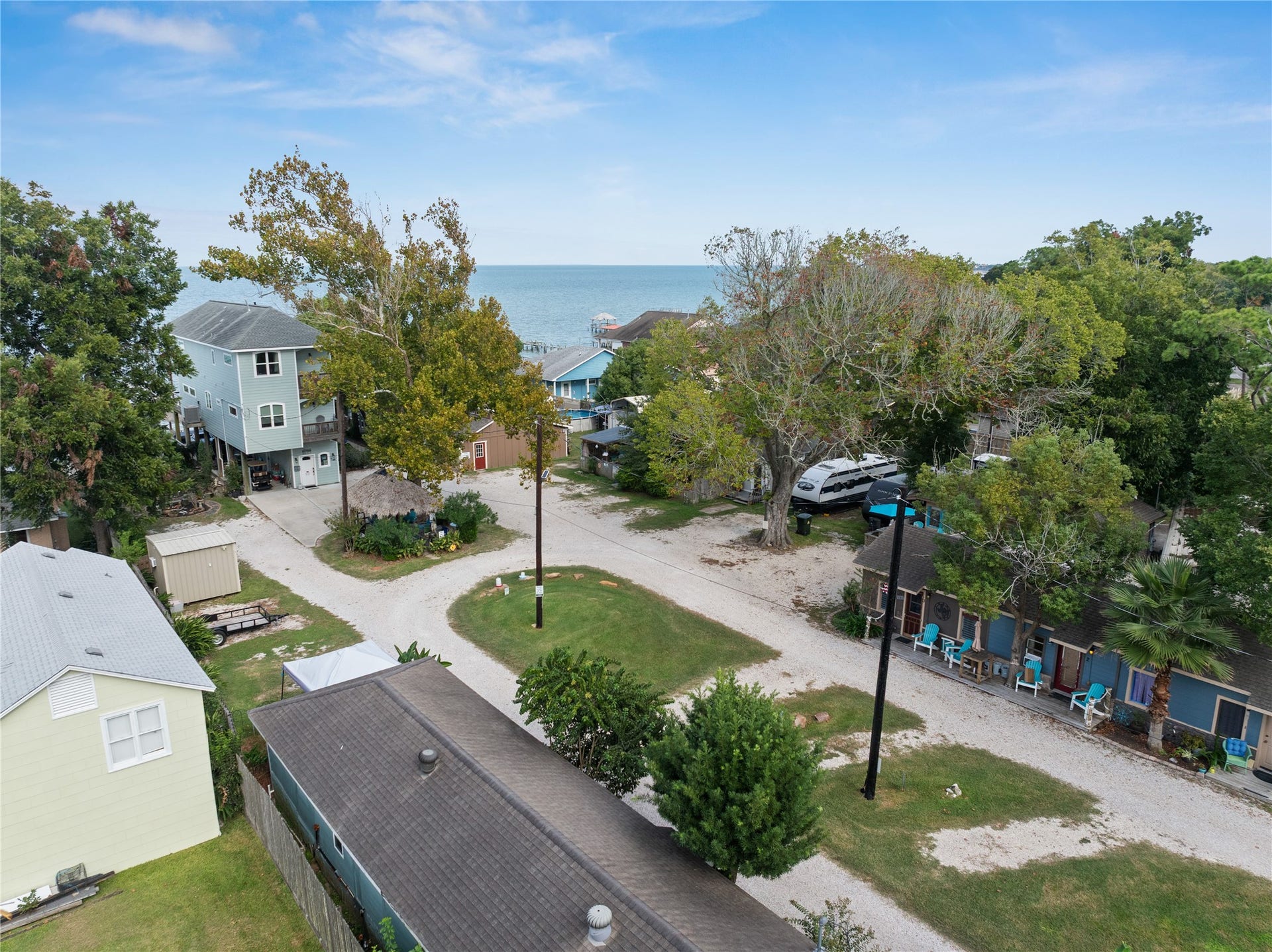 3709 Bayshore Drive, #1-12, Bacliff, TX 77518 This photo shows the charming coastal property with a view of the bay. The homes and cottages are surrounded by trees, and a road leading to the waterfront, creating a peaceful, bay side atmosphere.
