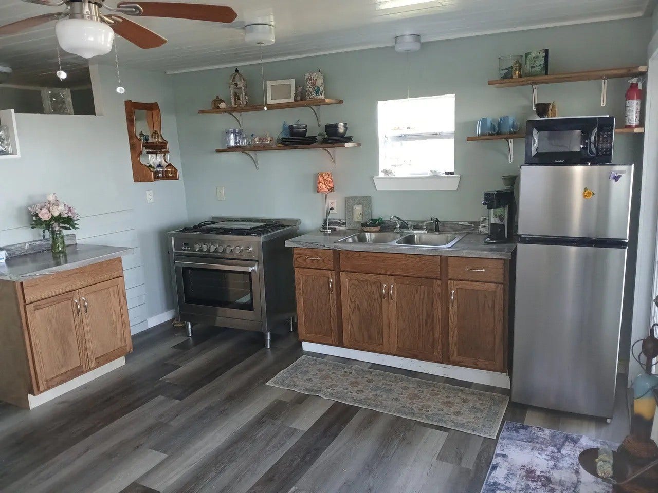3709 Bayshore Drive, #1-12, Bacliff, TX 77518 Charming kitchen in the La View with ample natural light and modern appliances, featuring open shelving and stylish wood cabinetry. Perfect for culinary enthusiasts!
