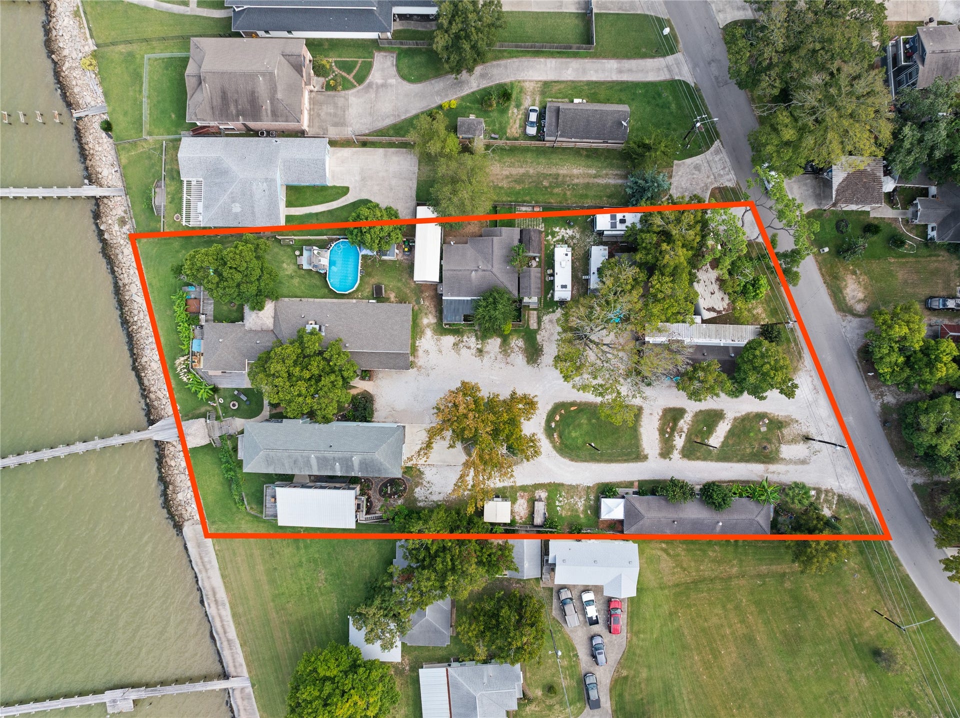 3709 Bayshore Drive, #1-12, Bacliff, TX 77518 This aerial photo shows the waterfront property bordered in red, featuring multiple buildings and mature trees. It has direct water access, a spacious layout, and is adjacent to a quiet neighborhood street.