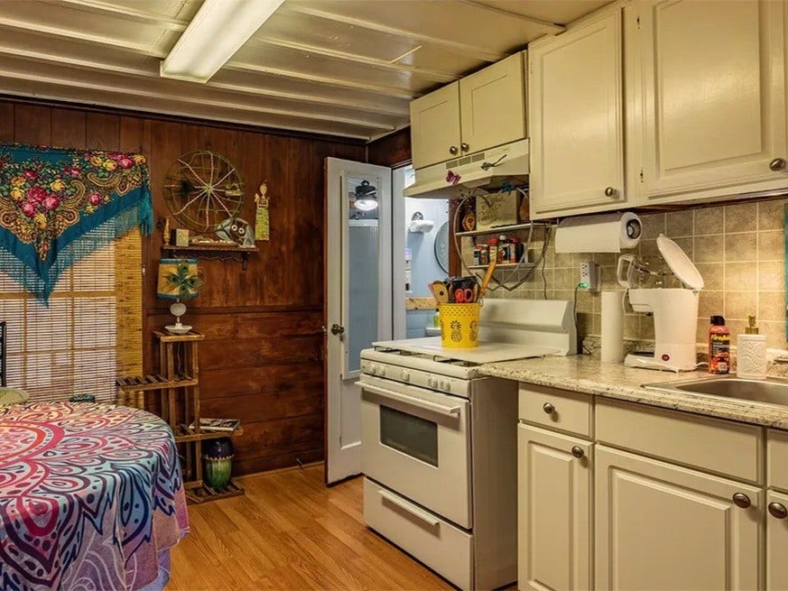 3709 Bayshore Drive, #1-12, Bacliff, TX 77518 Cozy and charming kitchen in the Saltwater Gypsy featuring rustic wood paneling and modern cabinetry, creating a unique blend of style and functionality. Perfect for creative cooking and intimate gatherings.