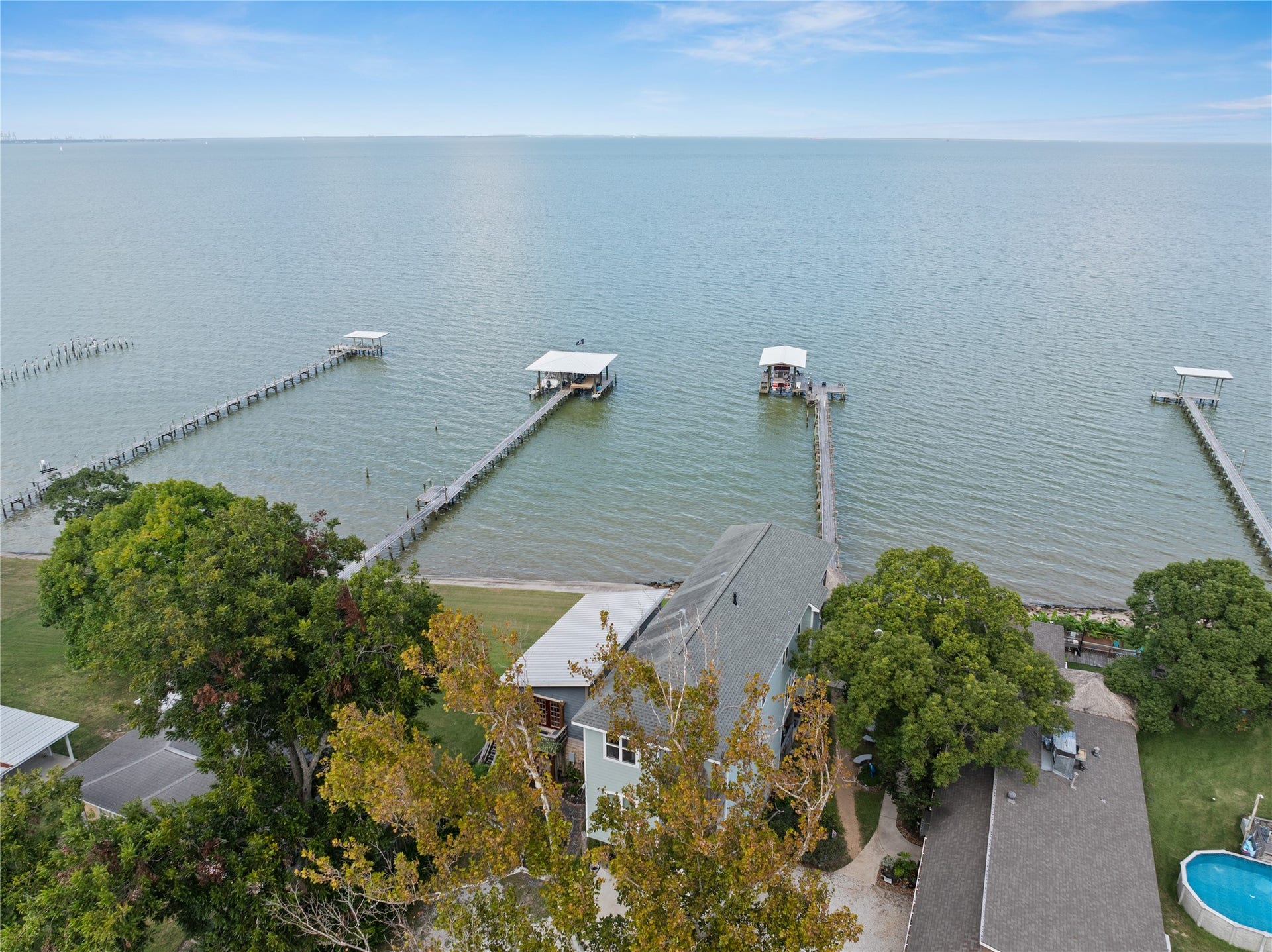 3709 Bayshore Drive, #1-12, Bacliff, TX 77518 This waterfront property is nestled among lush trees with direct access to a private pier extending into calm waters, offering stunning views and serene living by the bay.