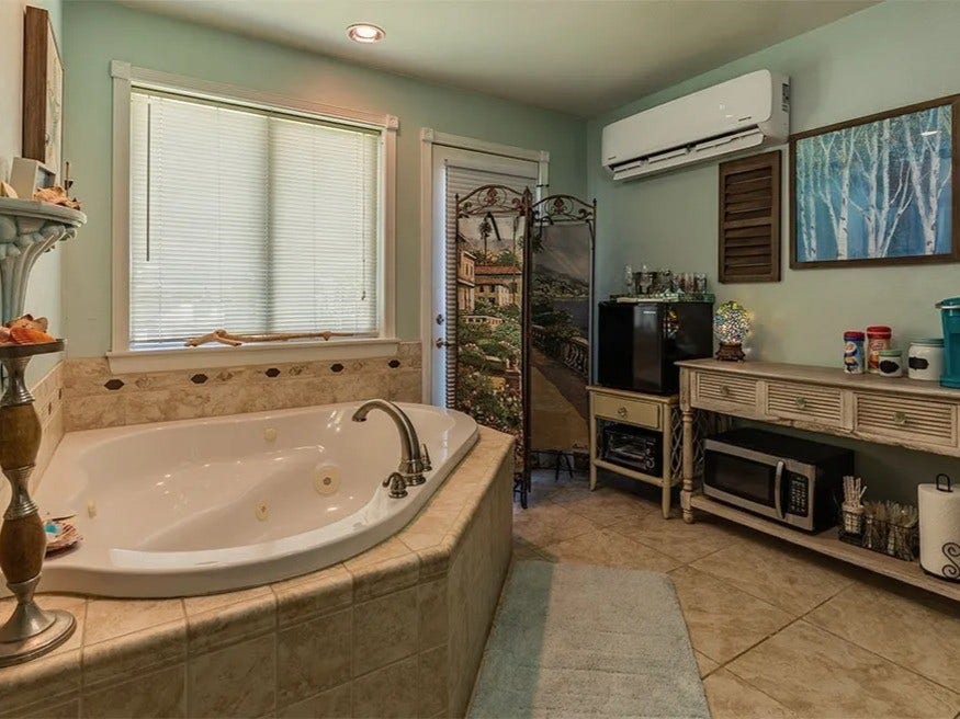 3709 Bayshore Drive, #1-12, Bacliff, TX 77518 Experience relaxation and style in this elegant Ohana House bathroom, featuring a luxurious soaking tub and charming decor.