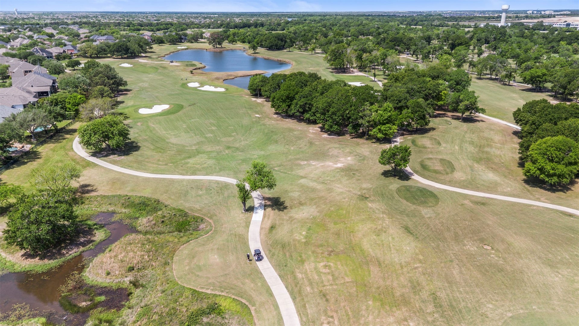 26418 Cottage Cypress Lane, Cypress, TX 77433 Stunning aerial view of BlackHorse Golf Clubs South Course, showcasing the expansive fairways, mature trees, water features and beautiful golf course setting just beyond the property.