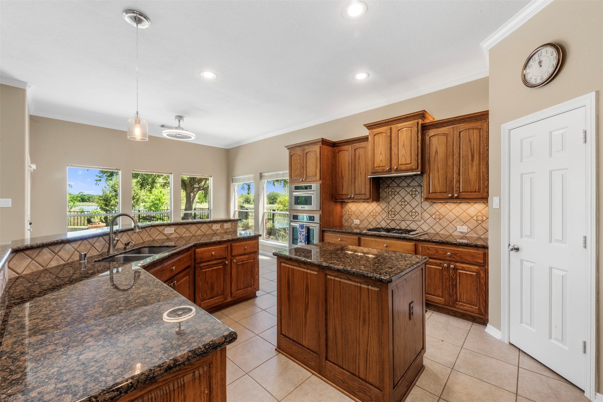 26418 Cottage Cypress Lane, Cypress, TX 77433 A chef-inspired kitchen with cabinetry and countertops, featuring a central island and large windows that offer a stunning view of the outdoors. Plenty of Storage.