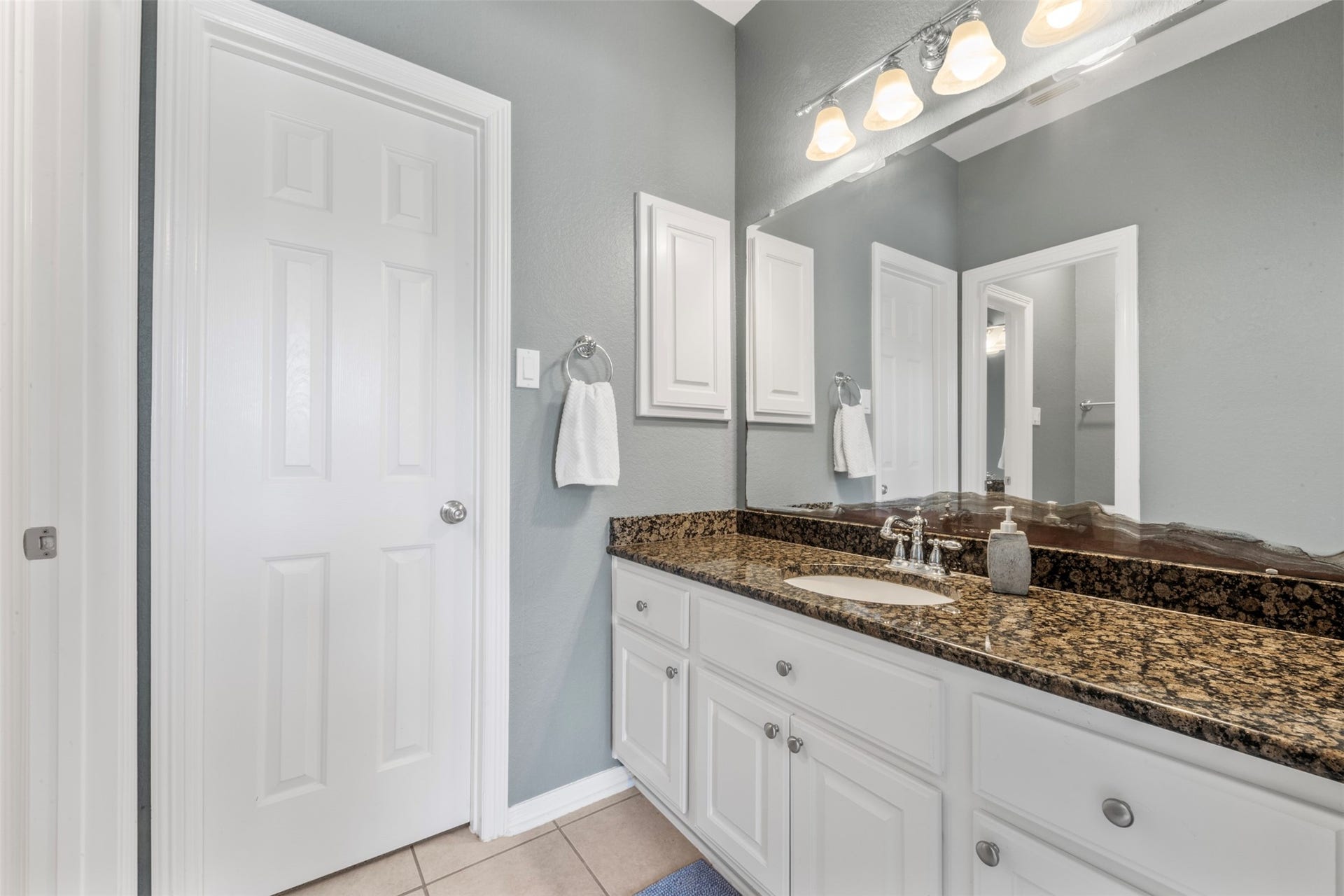 26418 Cottage Cypress Lane, Cypress, TX 77433 A stylish secondary bathroom featuring a vanity with bright finishes and ample extra storage in the dual cabinet, offering a fresh and functional feel.