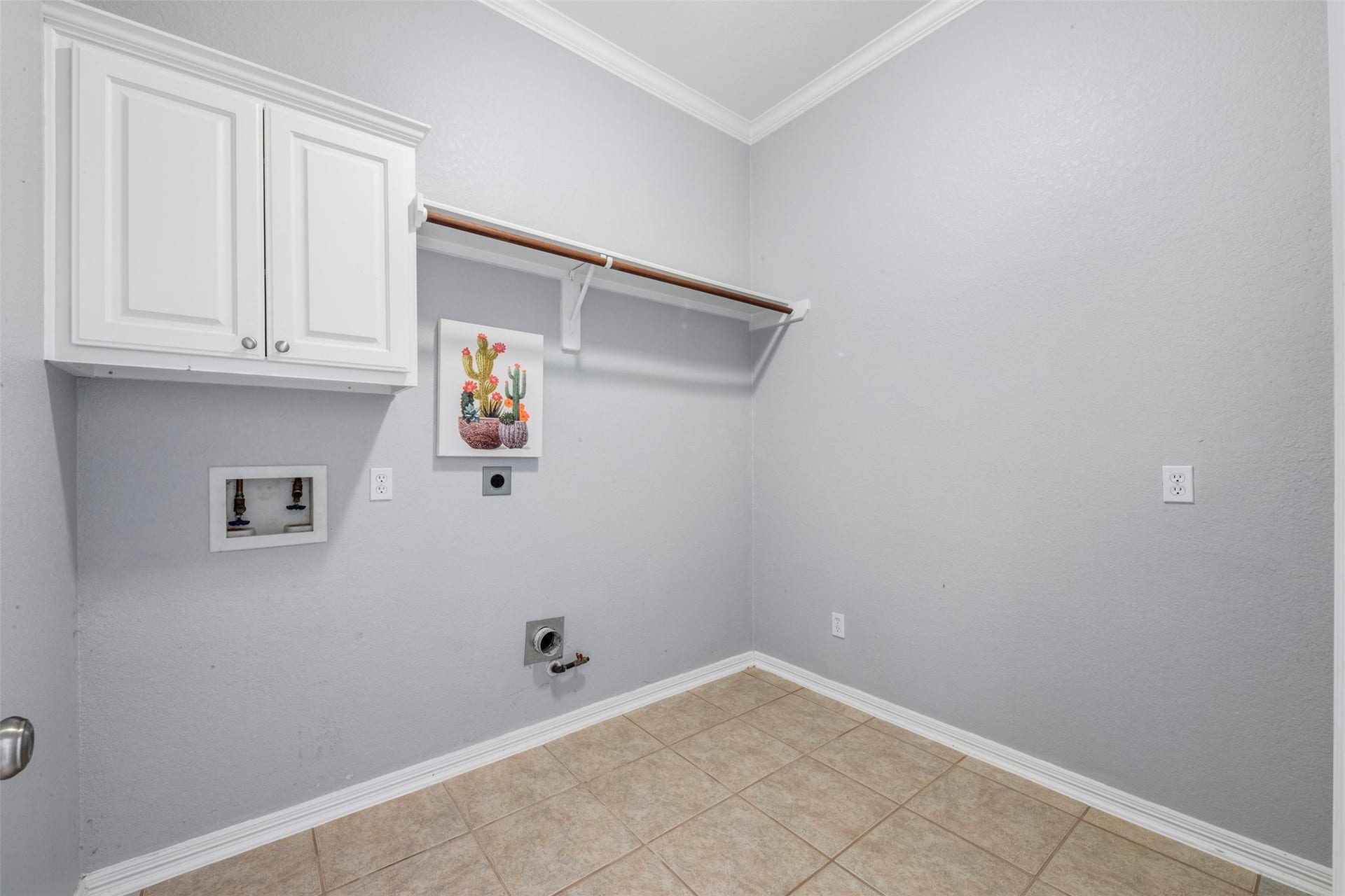 26418 Cottage Cypress Lane, Cypress, TX 77433 A functional laundry room featuring overhead cabinetry for organization, and a convenient hanging rod to help with daily tasks. The laundry room is right off the kitchen. Plenty of room for an extra refrigerator if necessary.