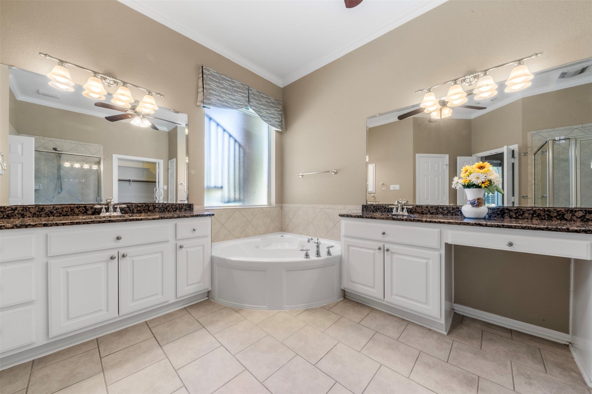26418 Cottage Cypress Lane, Cypress, TX 77433 A spa-like ensuite featuring dual vanities with countertops for extra storage and a soaking tub perfectly positioned under a large window for abundant natural light.