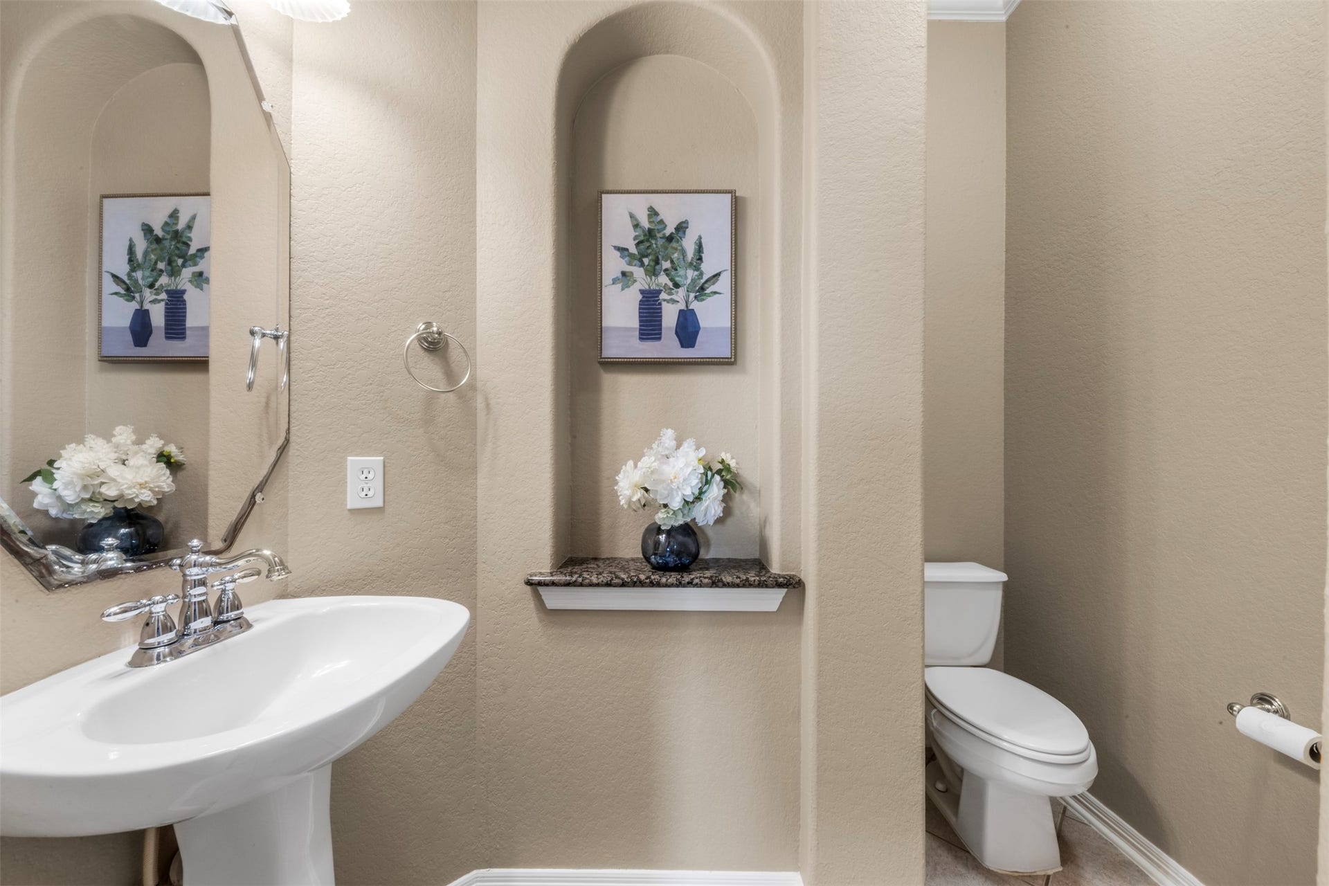 26418 Cottage Cypress Lane, Cypress, TX 77433 A stylish powder room featuring a classic pedestal sink and a clean, polished look that welcomes guests. This bathroom is located outside the primary bedroom and second bedroom downstairs.