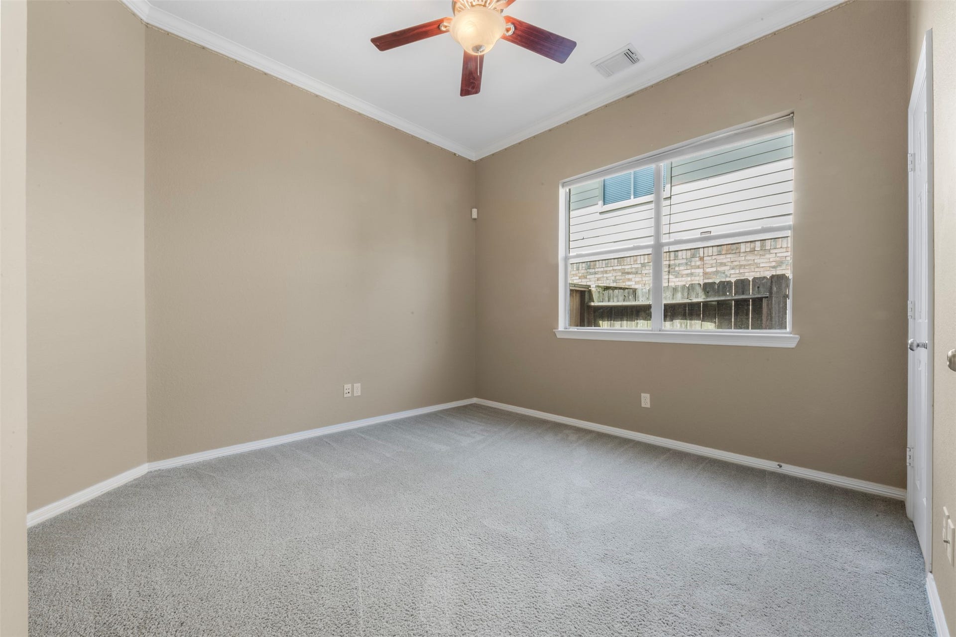 26418 Cottage Cypress Lane, Cypress, TX 77433 A cozy secondary bedroom on the 1st floor. Added ceiling fan for comfort, with a large window that provides abundant natural light over soft, neutral carpeting. This bedroom has an en-suite bathroom.