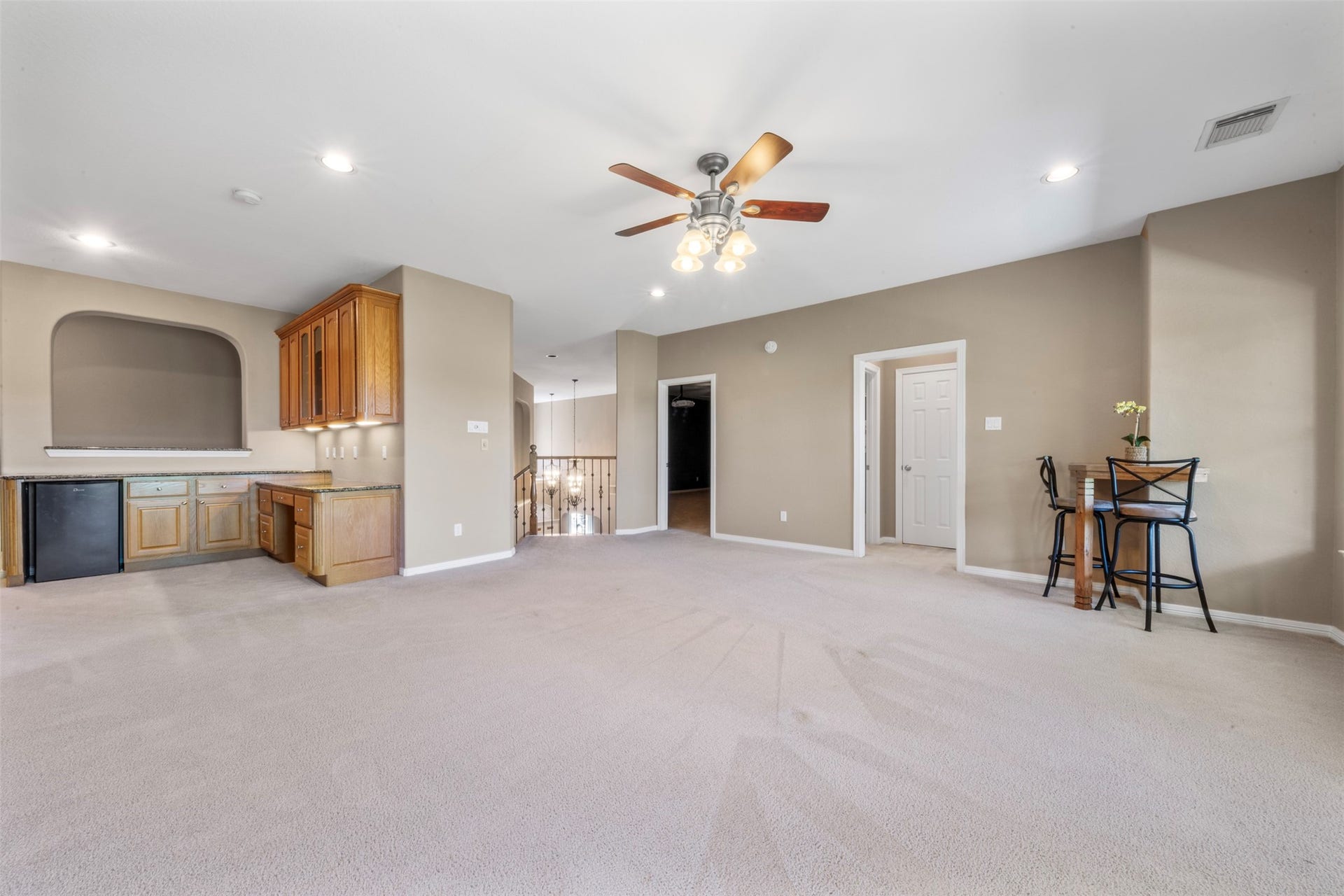 26418 Cottage Cypress Lane, Cypress, TX 77433 A versatile open-concept space featuring a delightful wet bar with custom cabinetry and ample space for easy relaxation or entertaining. The game room has a built-in desk with cabinets as well as a refrigerator.