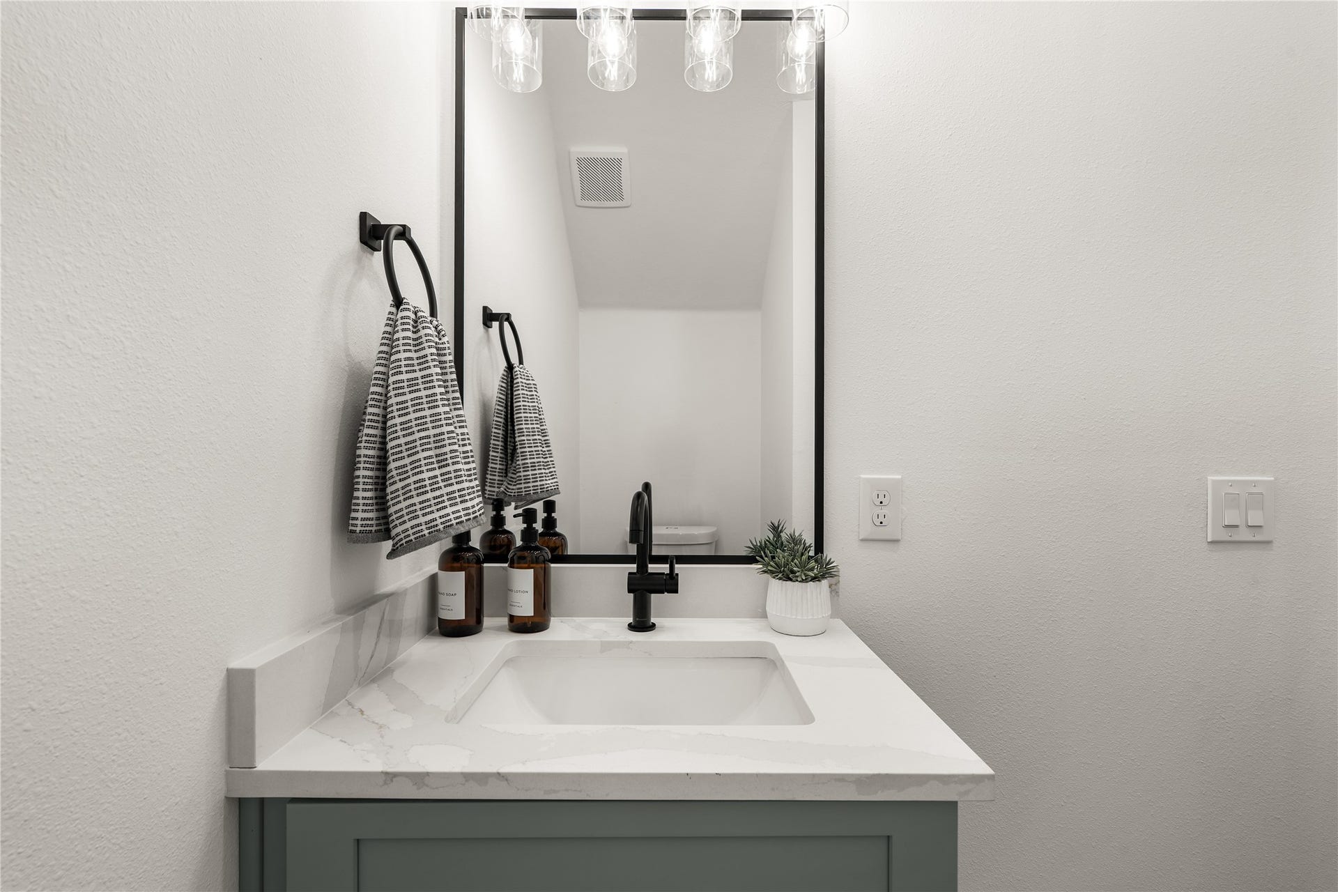 3412 Cortlandt Street, Houston, TX 77018 The powder room has its own character: a sage green vanity, veined quartz countertop, and matte-black
fixtures give guests a polished, boutique-inspired moment.