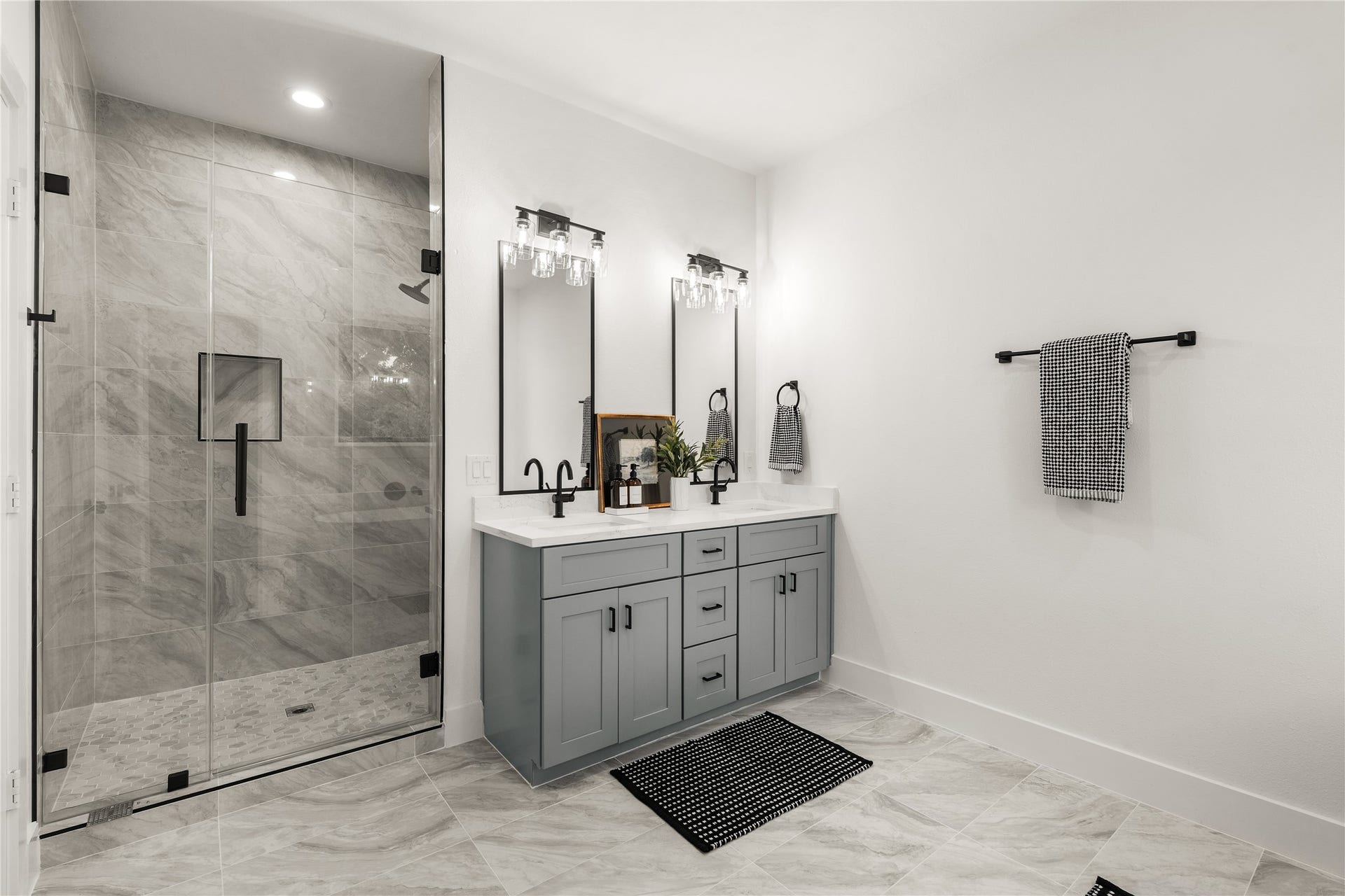 3412 Cortlandt Street, Houston, TX 77018 The spa-inspired primary bath pairs a frameless glass walk-in shower wrapped in large-format marble-look
tile with a double vanity, recessed niche, and matte-black fixtures for a crisp, tailored finish.