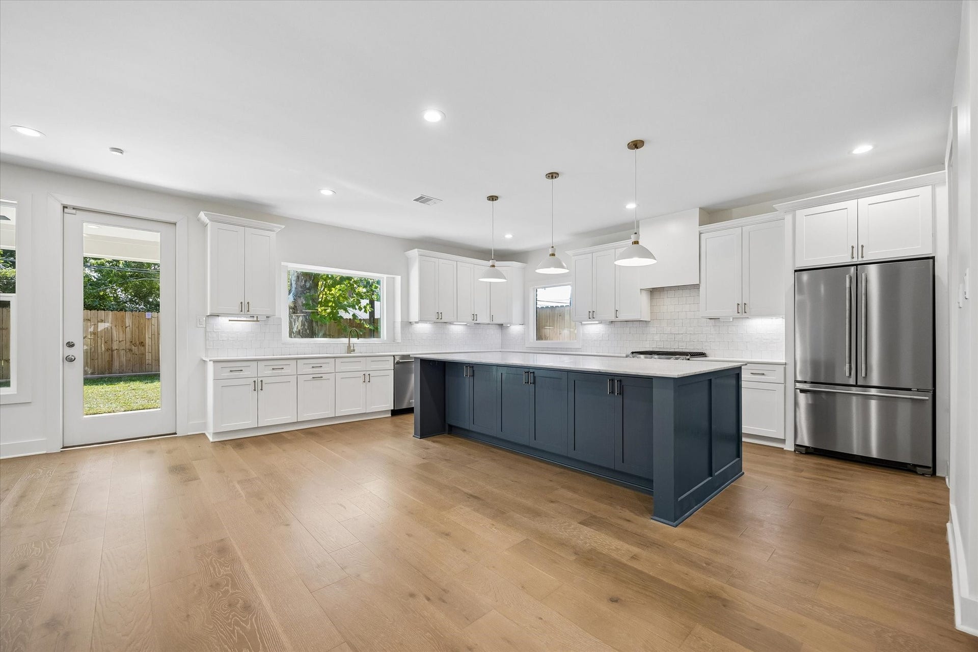 10659 Mayfield Road, Houston, TX 77043 The kitchen features a contemporary design with ample cabinetry and a generous island, providing both functionality and style. Large windows ensure the space is bathed in natural light, while pendant lights above the island add a modern touch. This kitchen is perfect for both cooking and casual dining.