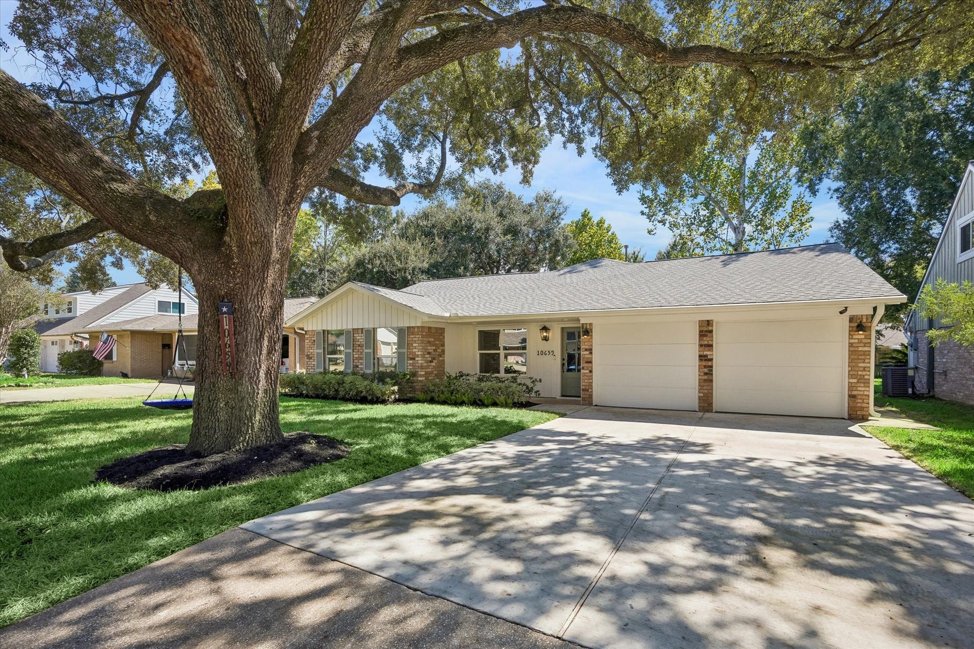 10659 Mayfield Road, Houston, TX 77043 This charming property at 10659 Mayfield Road boasts a beautifully updated facade with a blend of brick and fresh white siding, complemented by a vibrant front door. The spacious front yard, shaded by a large tree, enhances the home's curb appeal. This welcoming exterior sets the tone for the inviting interior waiting to greet you.