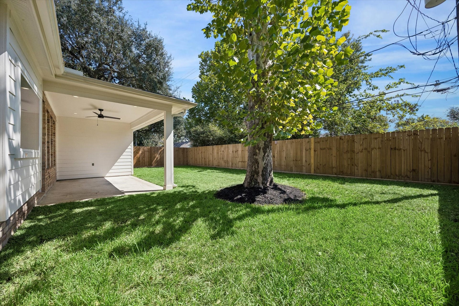 10659 Mayfield Road, Houston, TX 77043 The backyard offers a spacious canvas ready for your personal touch. With a covered patio area featuring a ceiling fan, this space is perfect for outdoor relaxation and gatherings.