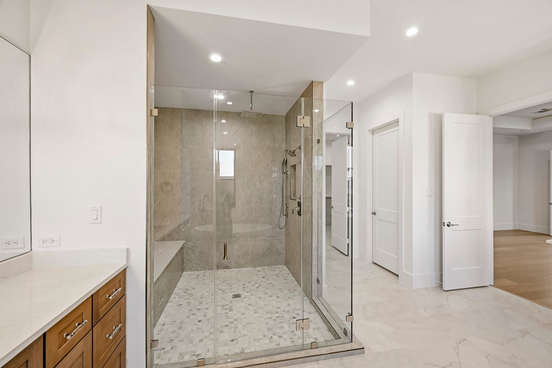 The shower boasts 4 sprayers, a bench, and a niche!
