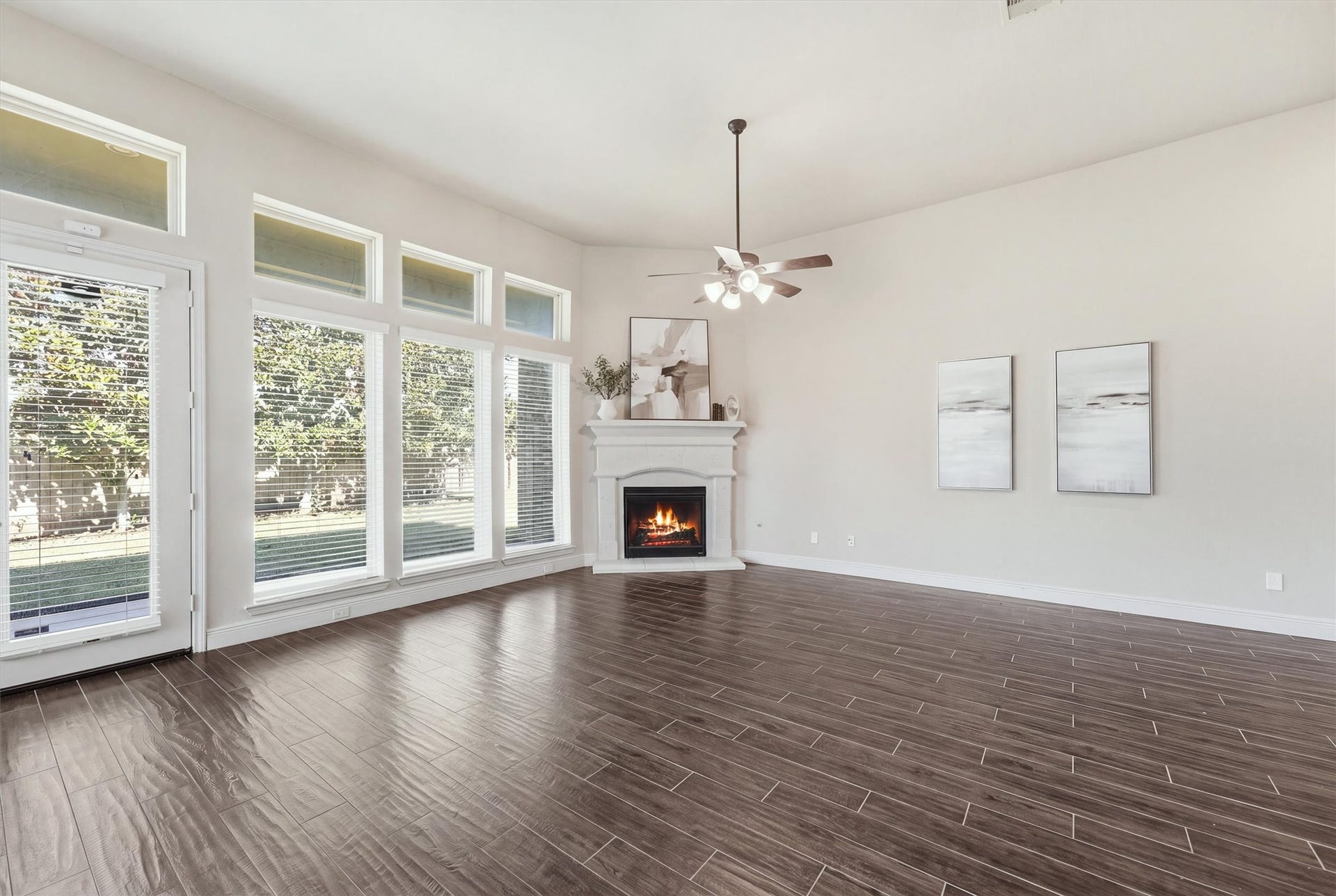 Spacious family room with high ceilings, a wall of windows, and cast-stone fireplace.