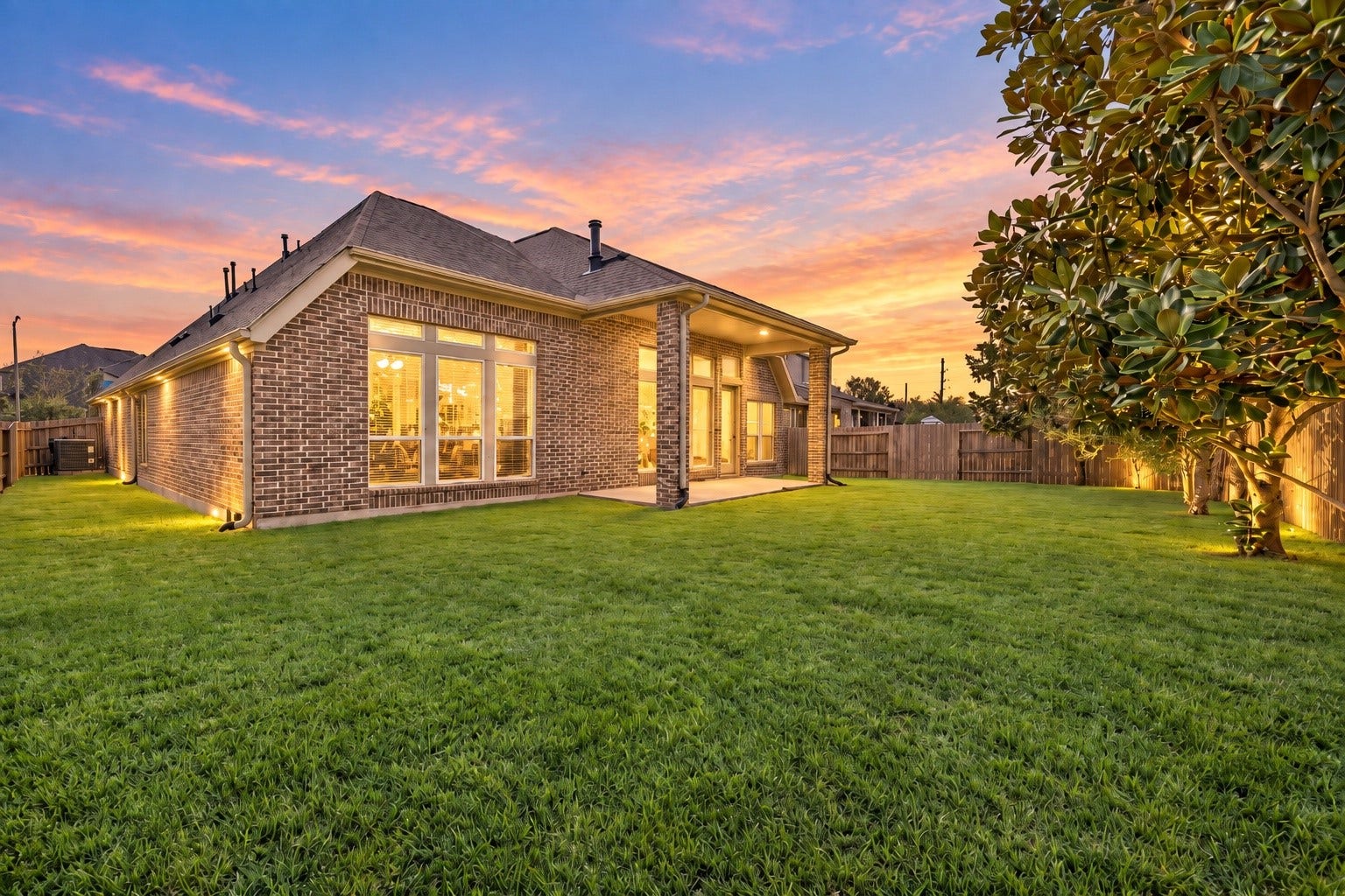 Four-sided brick exterior with a spacious backyard and covered patio.