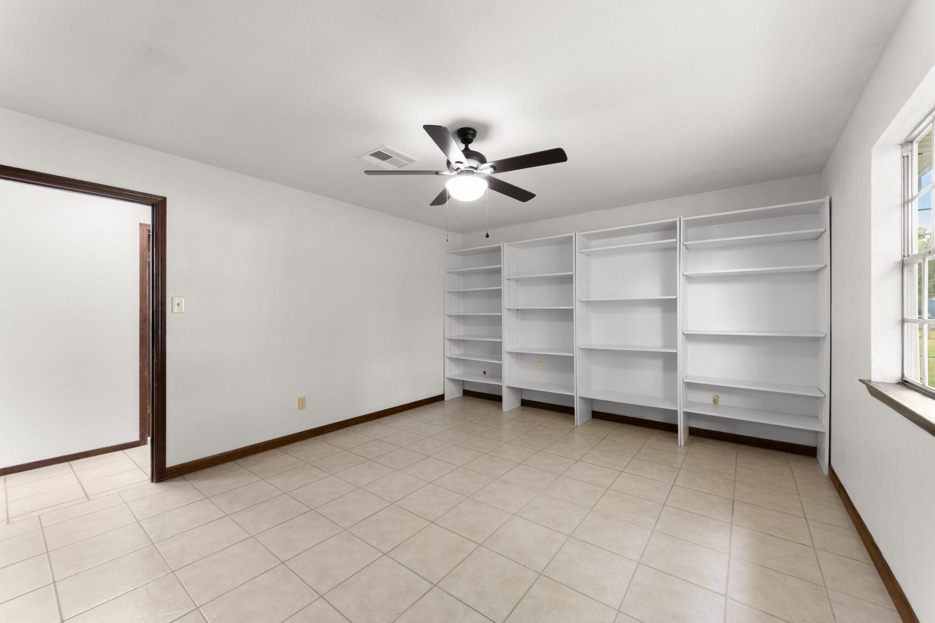 11325 32nd Street, Santa Fe, TX 77510 Extensive removable shelving provides excellent space for books, collectibles, or organized storage, adding versatility to the primary bedroom.